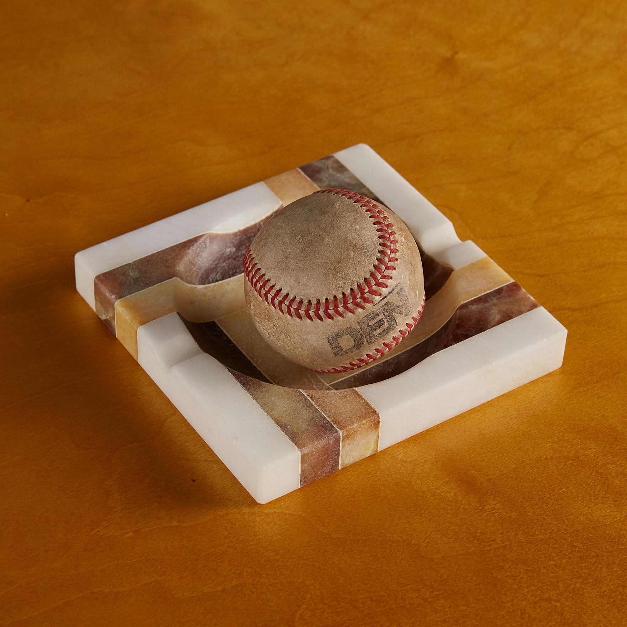 A honed square ashtray with a low profile and wide bowl in polished alabaster. The ashtray features a geometric linear design in caramel and camel which elevates the relatively simple design. This piece can be used for its original purpose or as a