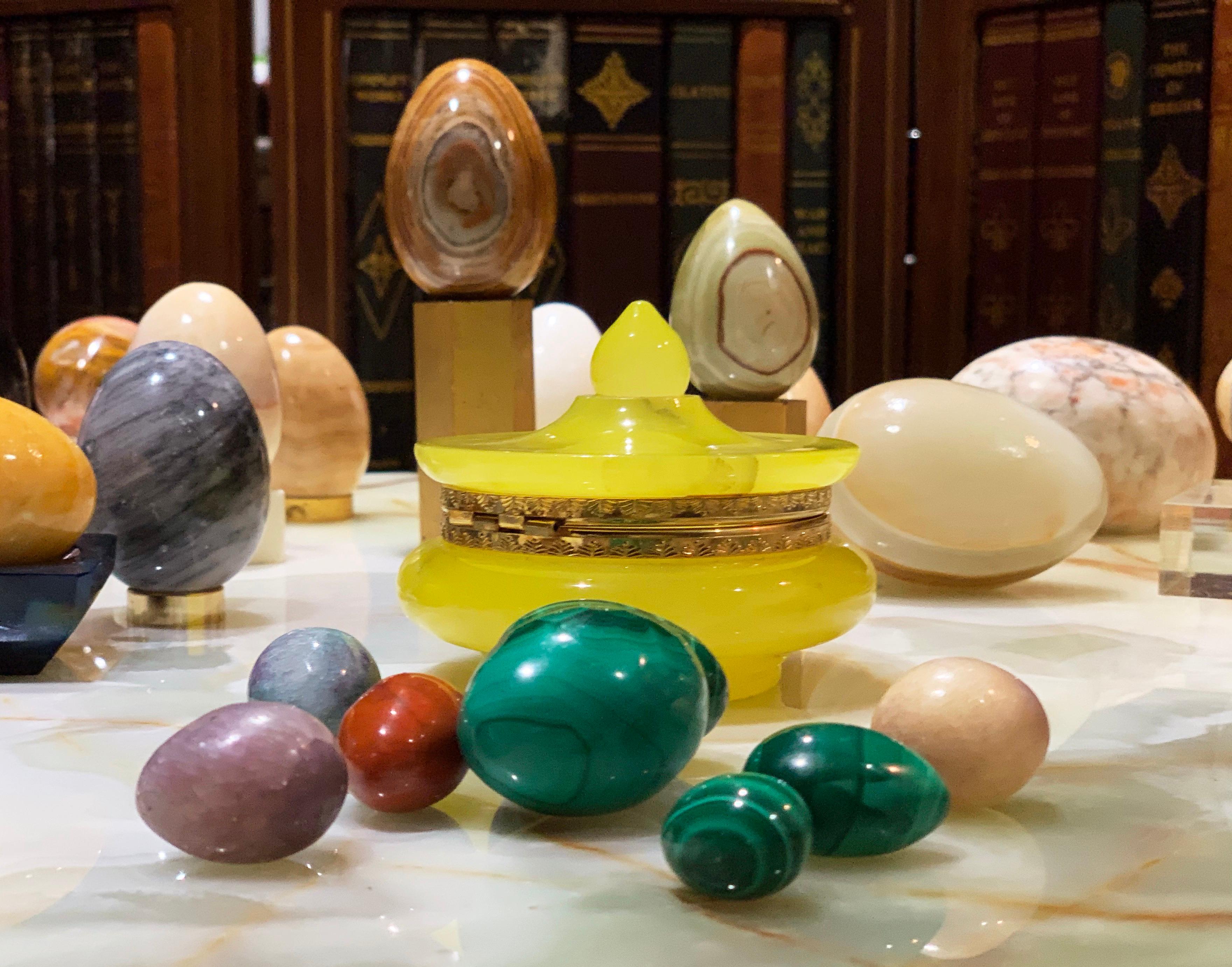 Organic modern hand carved stone egg sculptural set with heavy guilt brass bases. Midcentury. Trinket box with label. Gorgeous sculptural set. Vibrant color and finely finished. Set includes box with 8 eggs of various sizes and materials, including