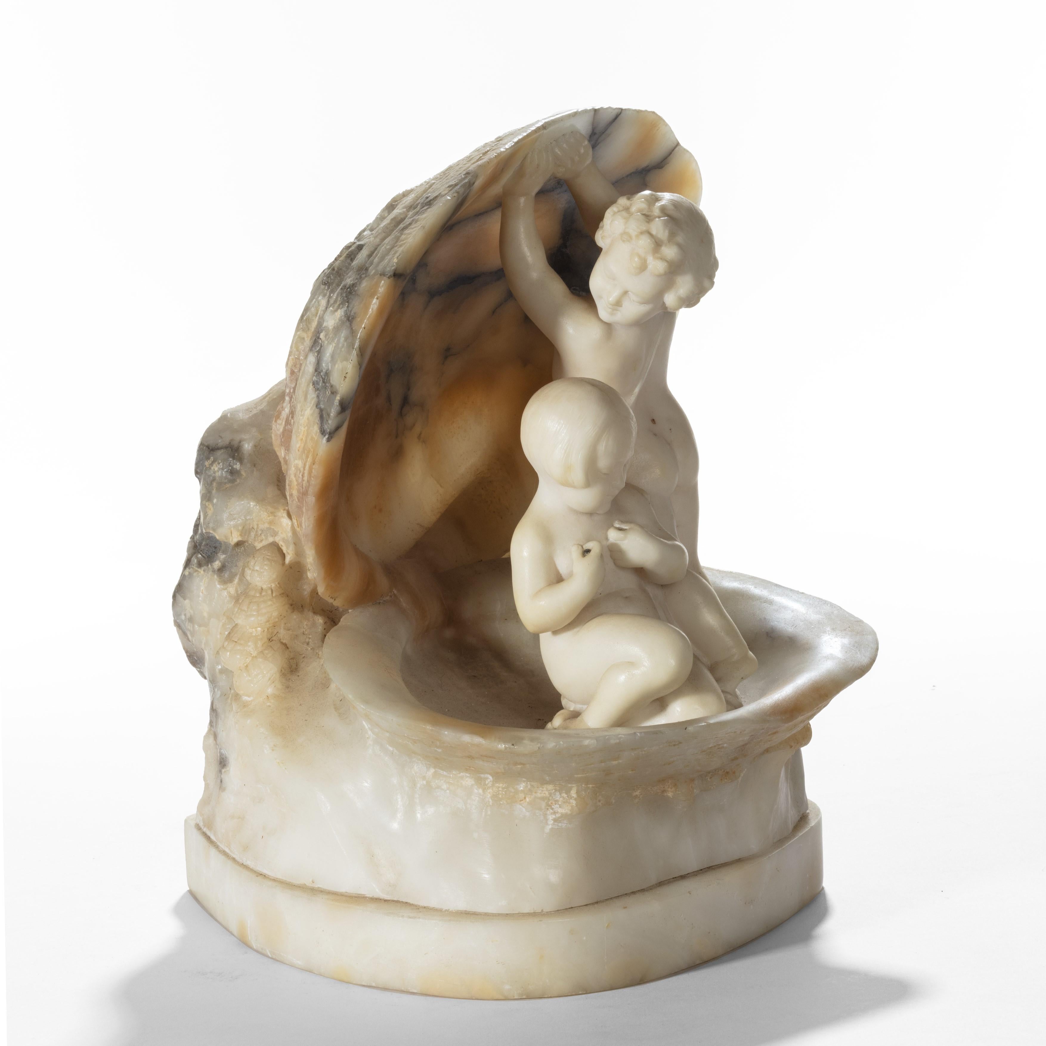 A charming Italian alabaster lamp, comprising two children sitting in a clam shell, one holding the clam open while the other clutches some pearls, fitted for electricity, circa 1920.
  