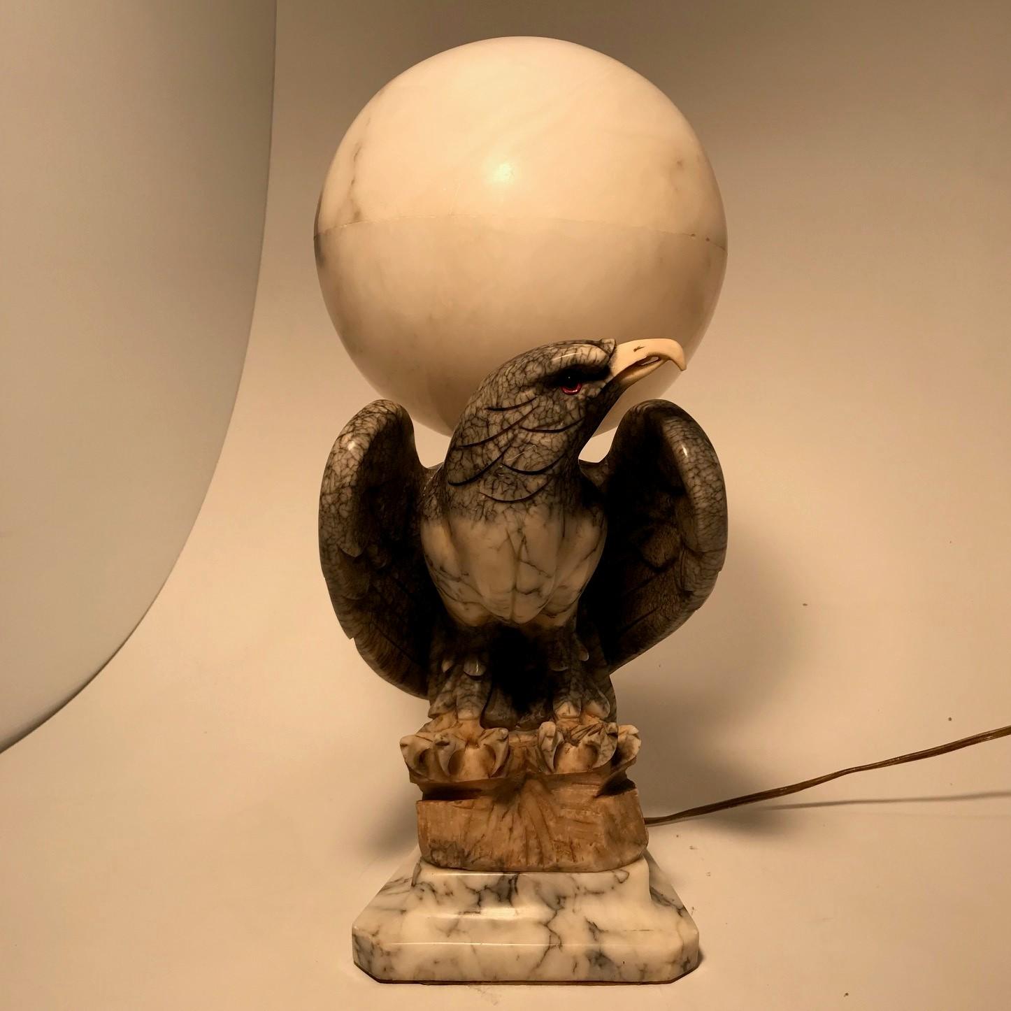 These sculptural lights in plain and stained alabaster are increasingly hard to find. This one, dating from perhaps the second quarter of the 20th century, is in exceptional condition, even the spherical shade is undamaged and unstained. The eagle