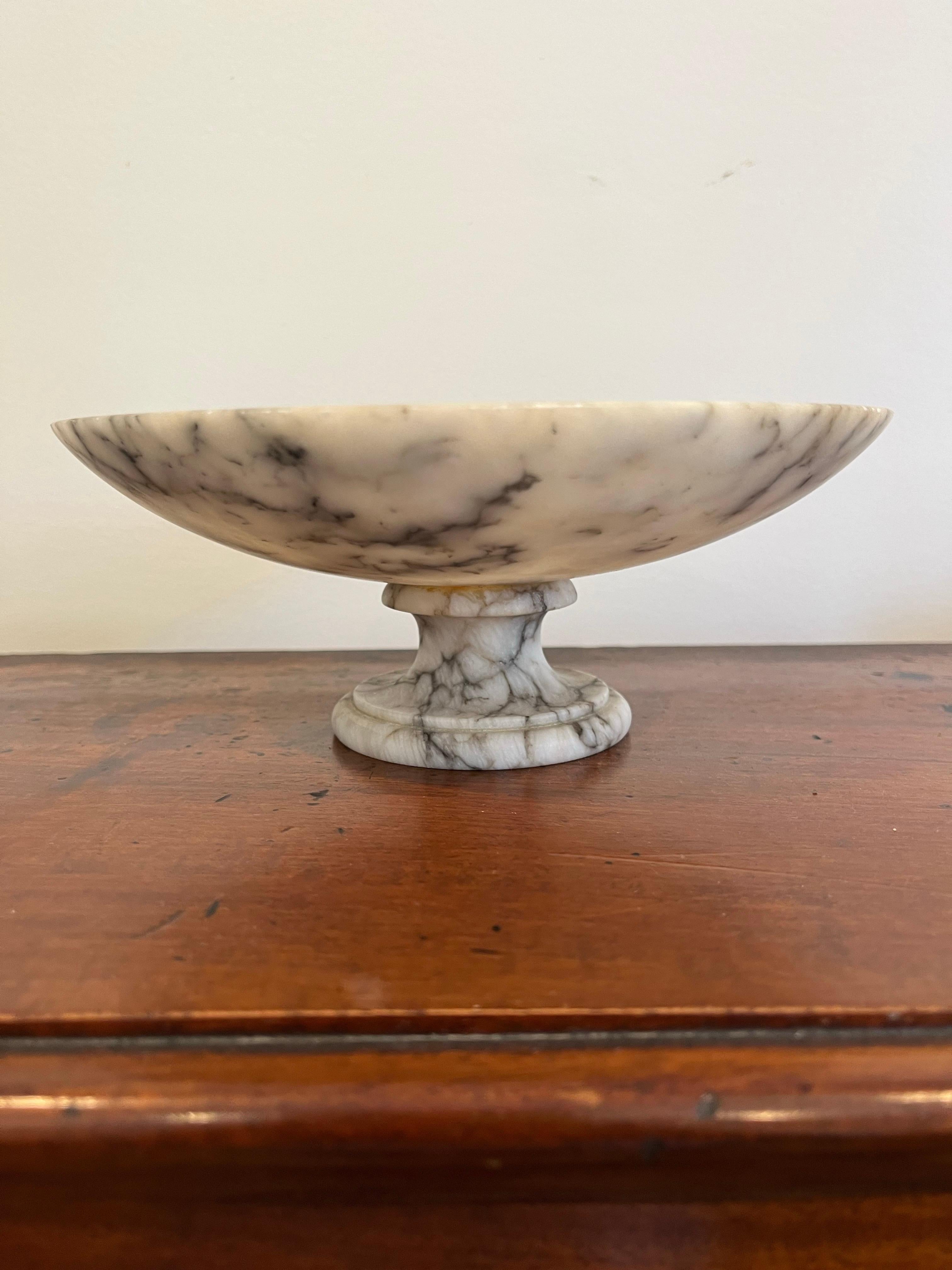 An Italian Modern alabaster marble tazza, fruit compote, bowl, catchall vide-poche, etc. circa mid-20th century, Italy. Piece is predominantly white with gray/black veining.