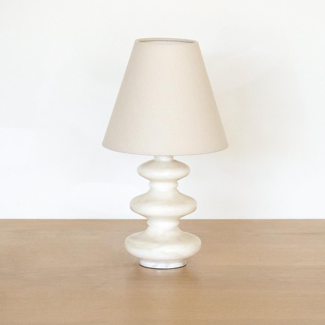 Beautiful Italian alabaster table lamp with 3 curvy tiers. Beautiful soft white creamy color with light veins in stone. Newly re-wired with new oyster linen shade.