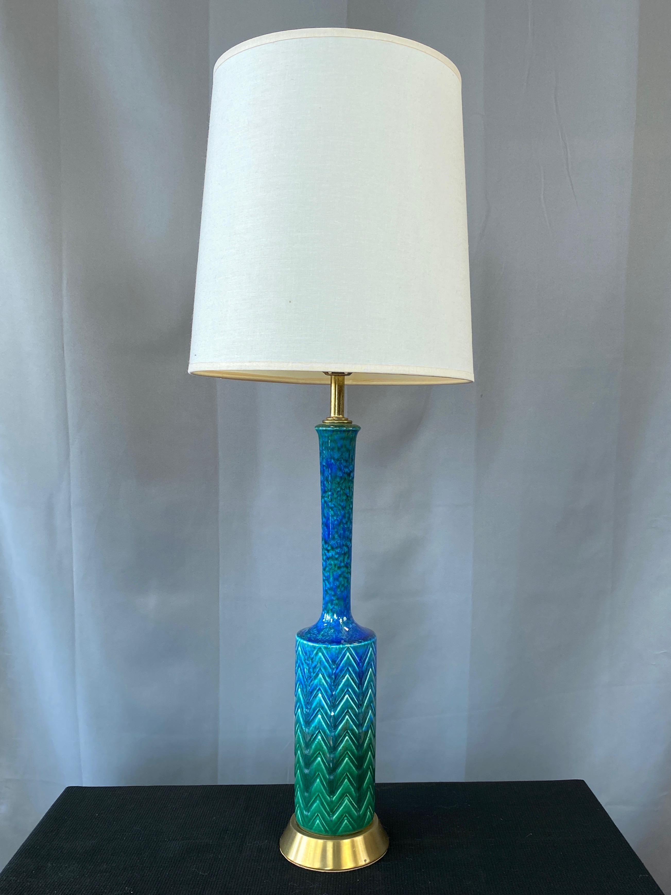 A delightfully proportioned and beautifully glazed 1960s Italian ceramic and brass table lamp in the style of Aldo Londi’s “Rimini blue” series for Bitossi.

Slender cylindrical body with stacked chevron motif in relief topped by a narrow
