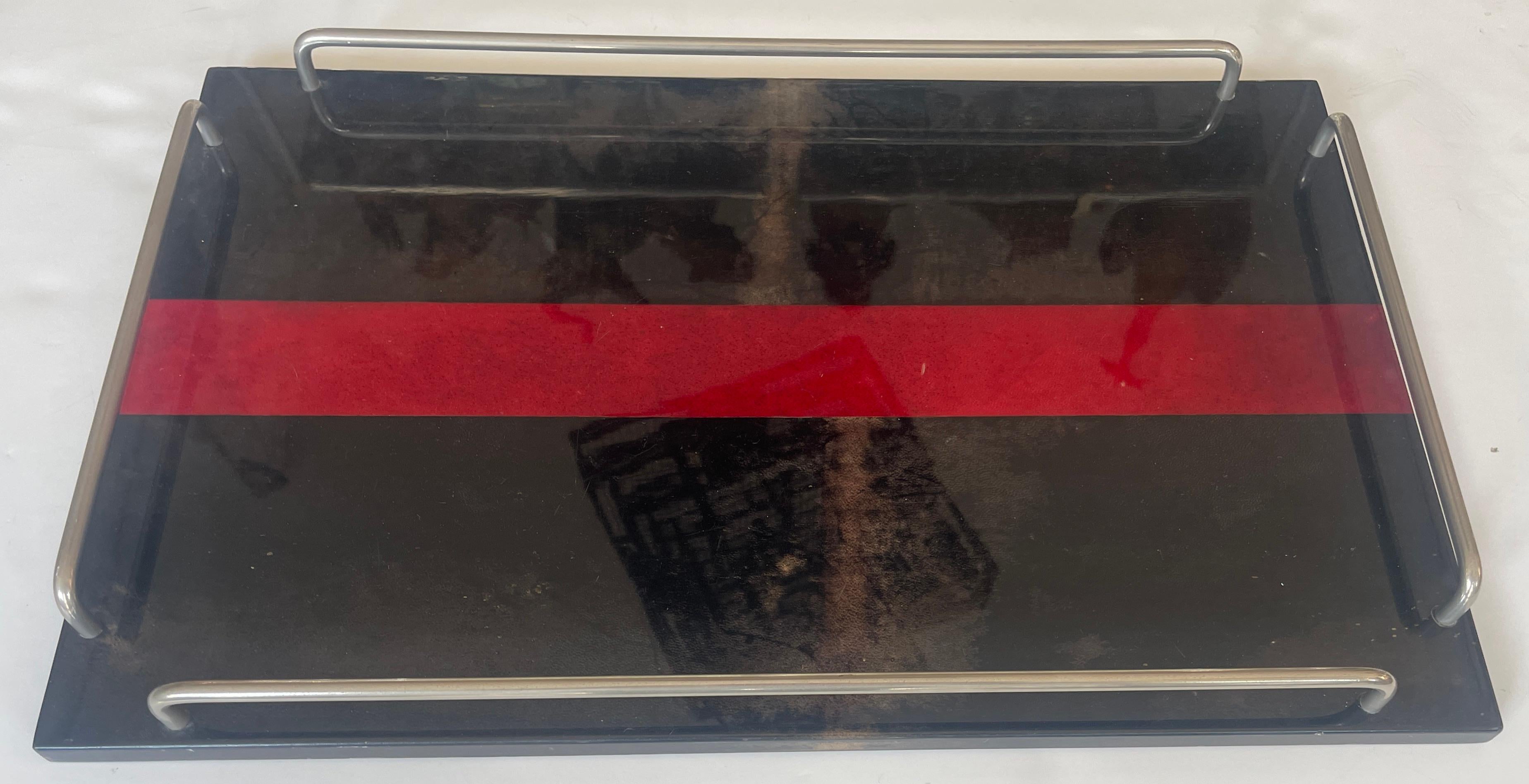 Voici un magnifique exemple de la grande peau de chèvre laquée en brun et rouge de l'Italien Aldo Tura, datant des années 1960.
Ce plateau est doté d'une galerie en métal argenté de chaque côté.
Ce plateau de service mesure 22