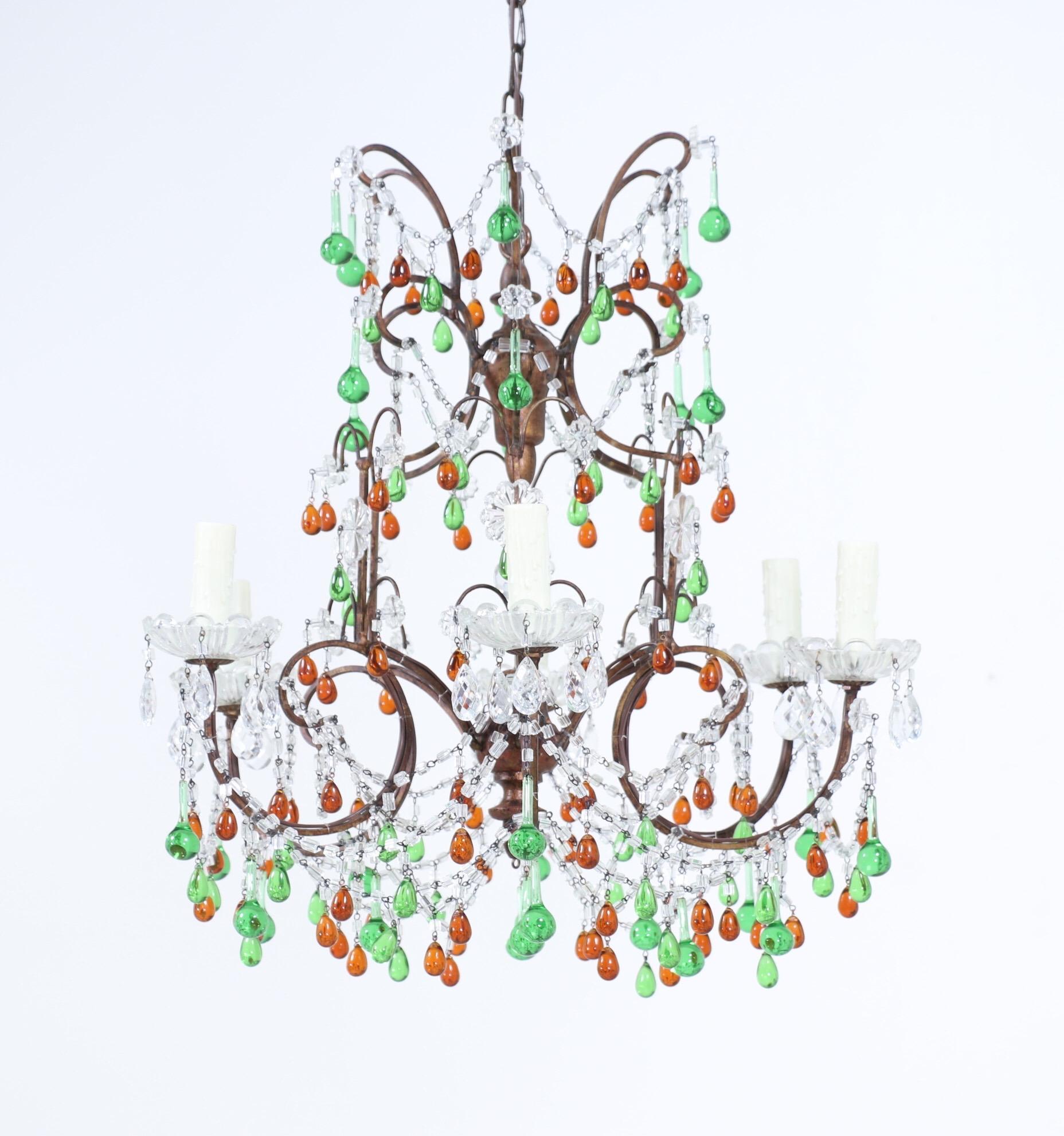 Festive, 1950s Italian giltwood and iron crystal beaded chandelier decorated with a bounty of green and amber Murano glass droplets. 

The chandelier consists of gilded wrought iron frame with a gilt-wood center. The chandelier is wired and in