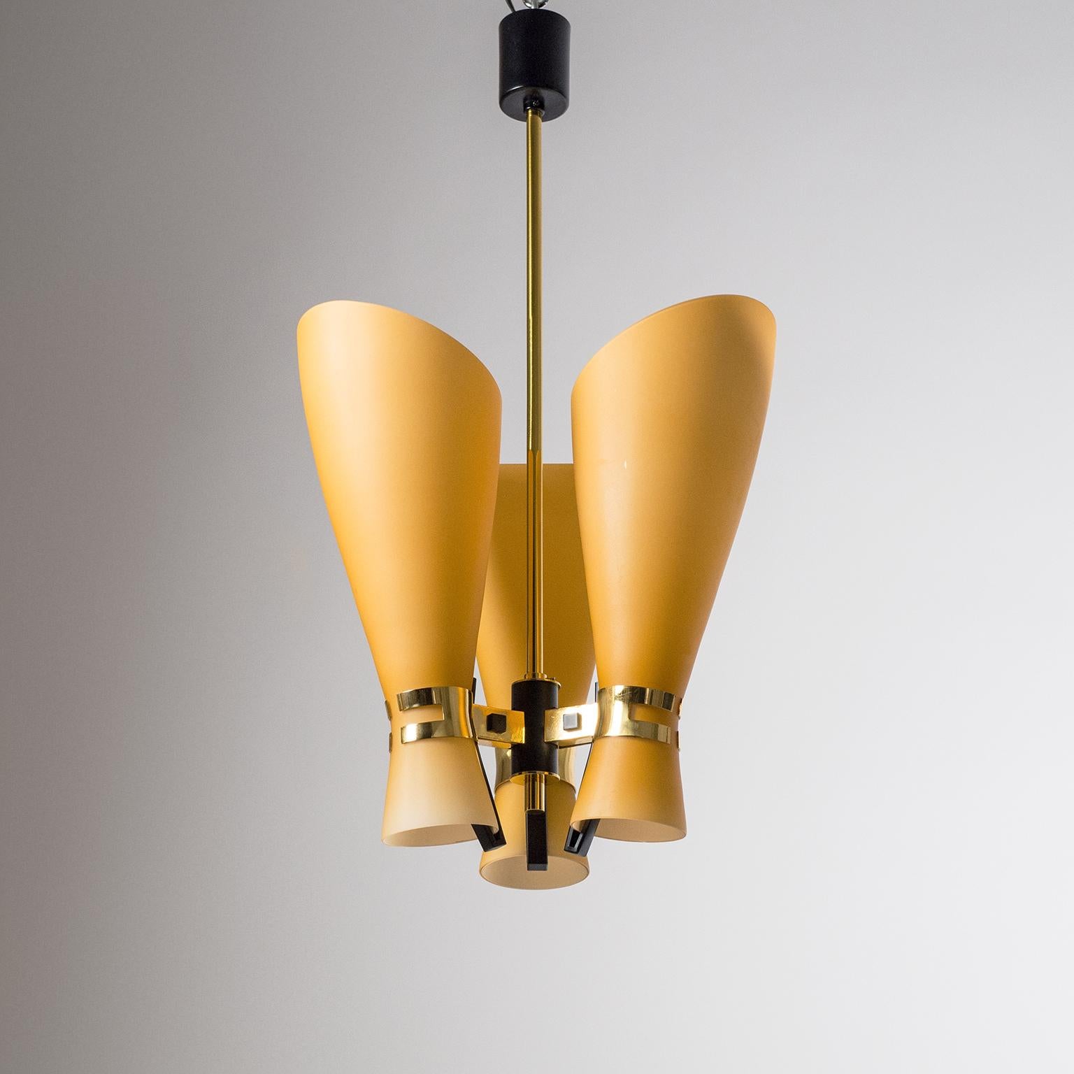 Rare Italian amber colored glass chandelier, circa 1960. Three large tapered glass diffusers are combined with minimal brass and black lacquered hardware. The blown glass diffusers are made of amber colored glass with white inner casing and satin