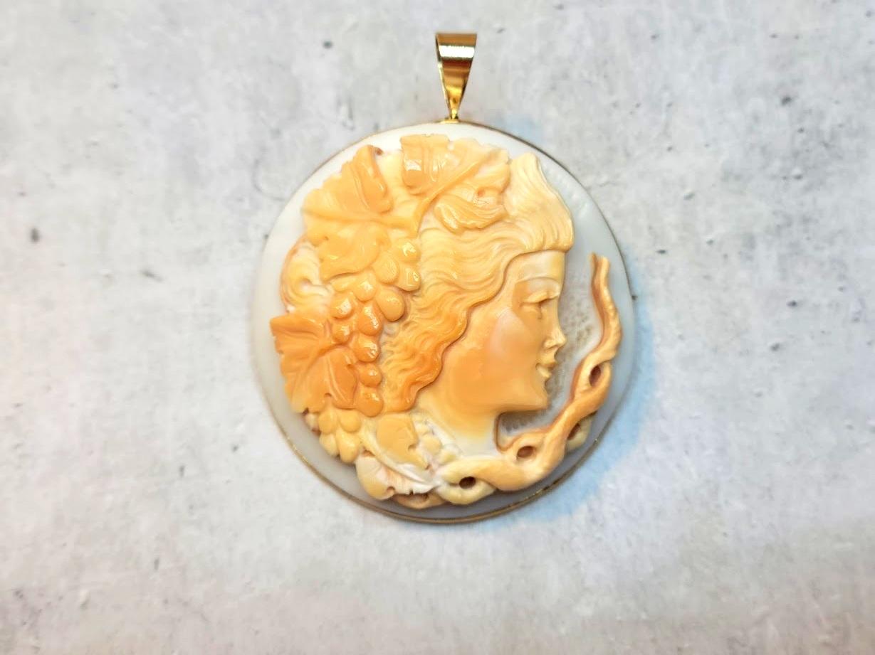 This shell cameo brooch pendant depicts Bacchus and dates back to the second half of the 20th century. It was masterfully crafted by the renowned company Amedeo by M+M Scognamiglio.
Each layer of the shell has been meticulously carved, unveiling a