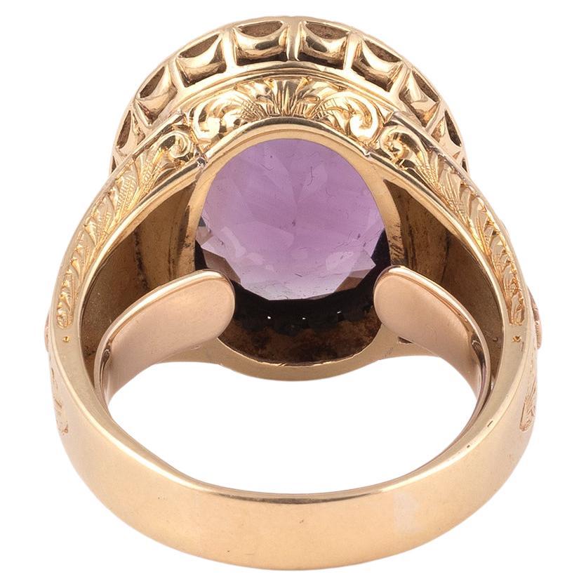 Oval amethyst approximately 7ct and 18kt yellow gold mount with a carved cross on each shoulder.
Size : 11 1/2
Weight:16,7gr.