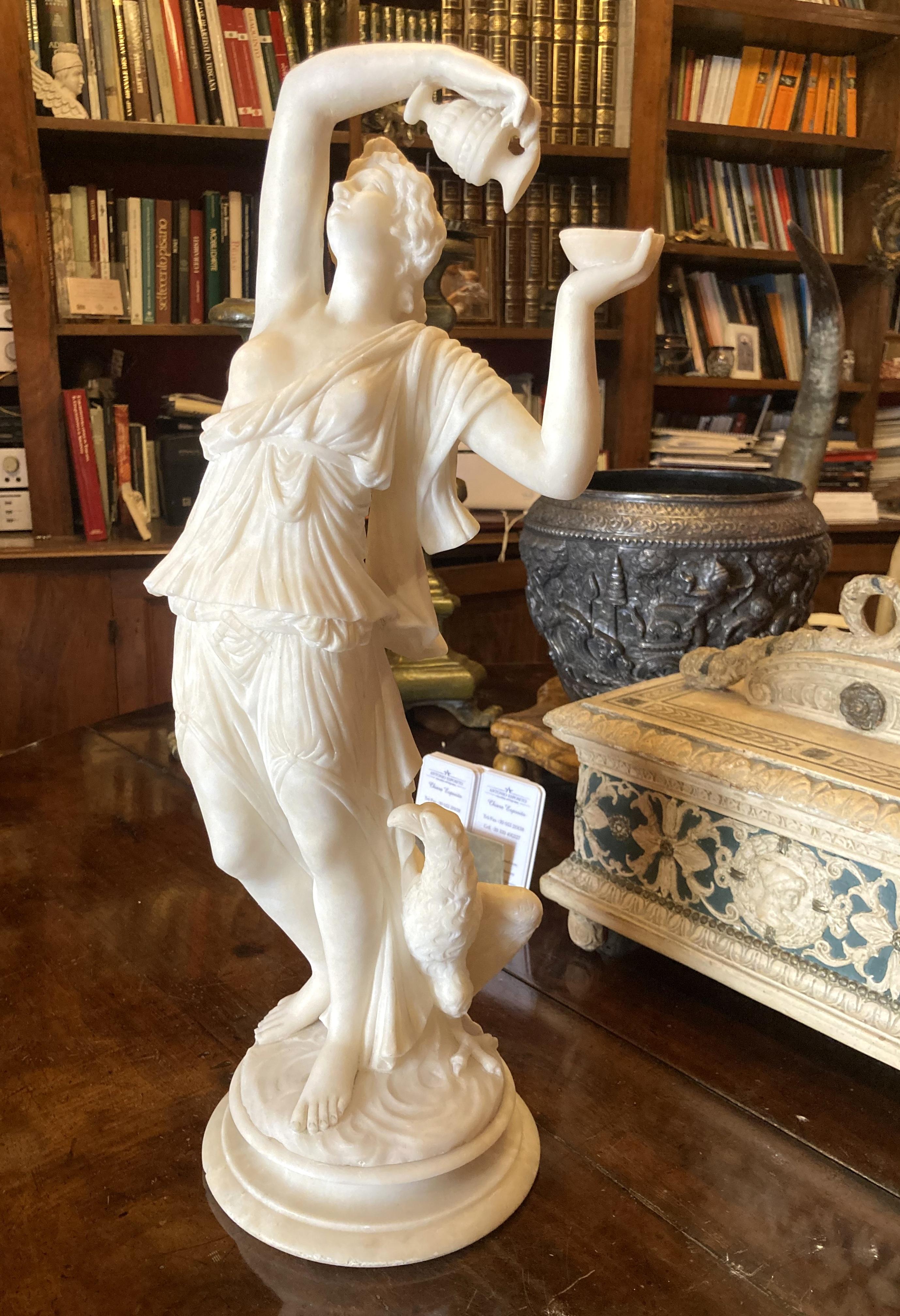 This srtiking Italian 19th century antique alabaster sculpture of a beautiful woman represents the Greek or Roman goddess of youth, Hebe, depicted as cupbearer to the gods, raising a vessel of the divine beverage ambrosia above her father, Jupiter,