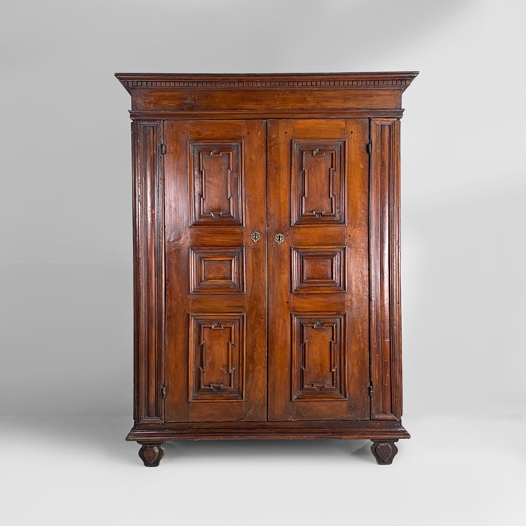 Armadio barocco italiano antico con ante, 1700
Armadio barocco in legno con ante. Mobile con ante a battente e due ripiani interni, con gambe anteriori con ornamento e gambe posteriori di forma irregolare e arrotondata. La cornice del cappello
