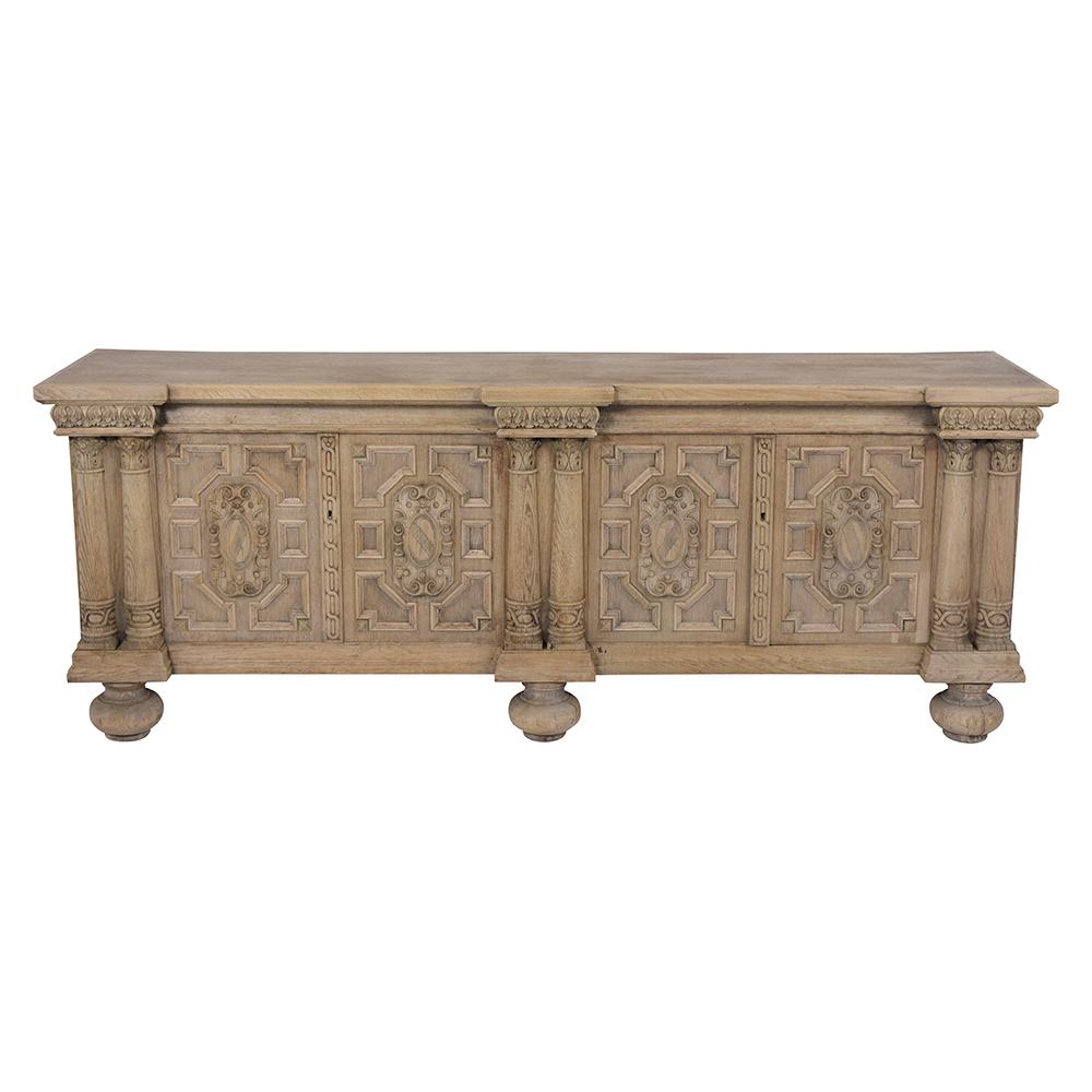 An Elegant Italian Baroque style Buffet made out of oak wood with an eye-catching bleached wood finish and has been newly restored. This fabulous piece features intricate hand-carved details throughout the entire piece, a front wood column, and four