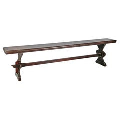 Italian antique dark wood bench with legs with decorated profiles, early 1900s