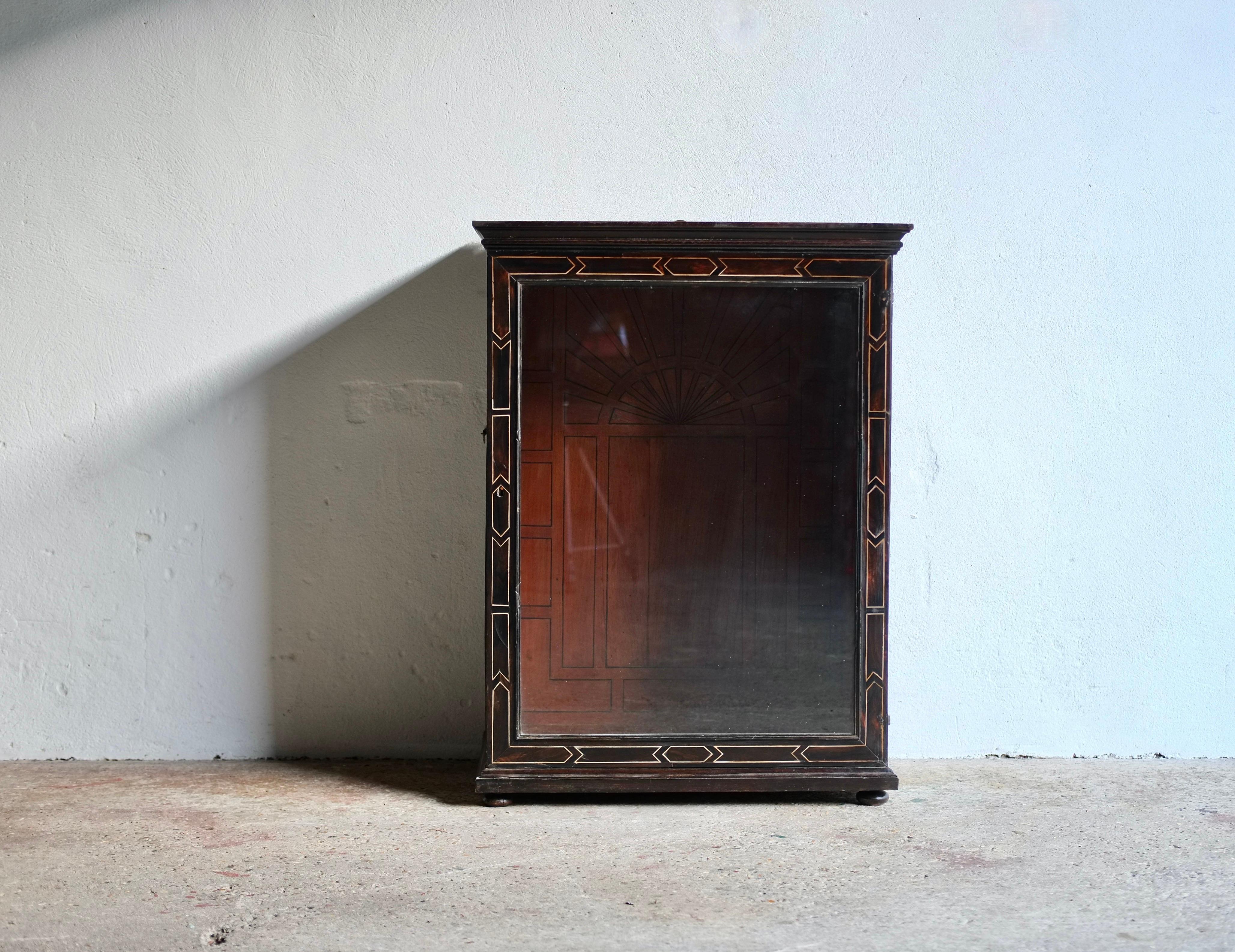 Antique ebonised fruitwood geometric inlaid pier cabinet, circa 19th century, Italy. 

In good condition. The glass in the door is not original. The inlay is believed to be ivory, as this is under 10% of the composition we have obtained an Ivory