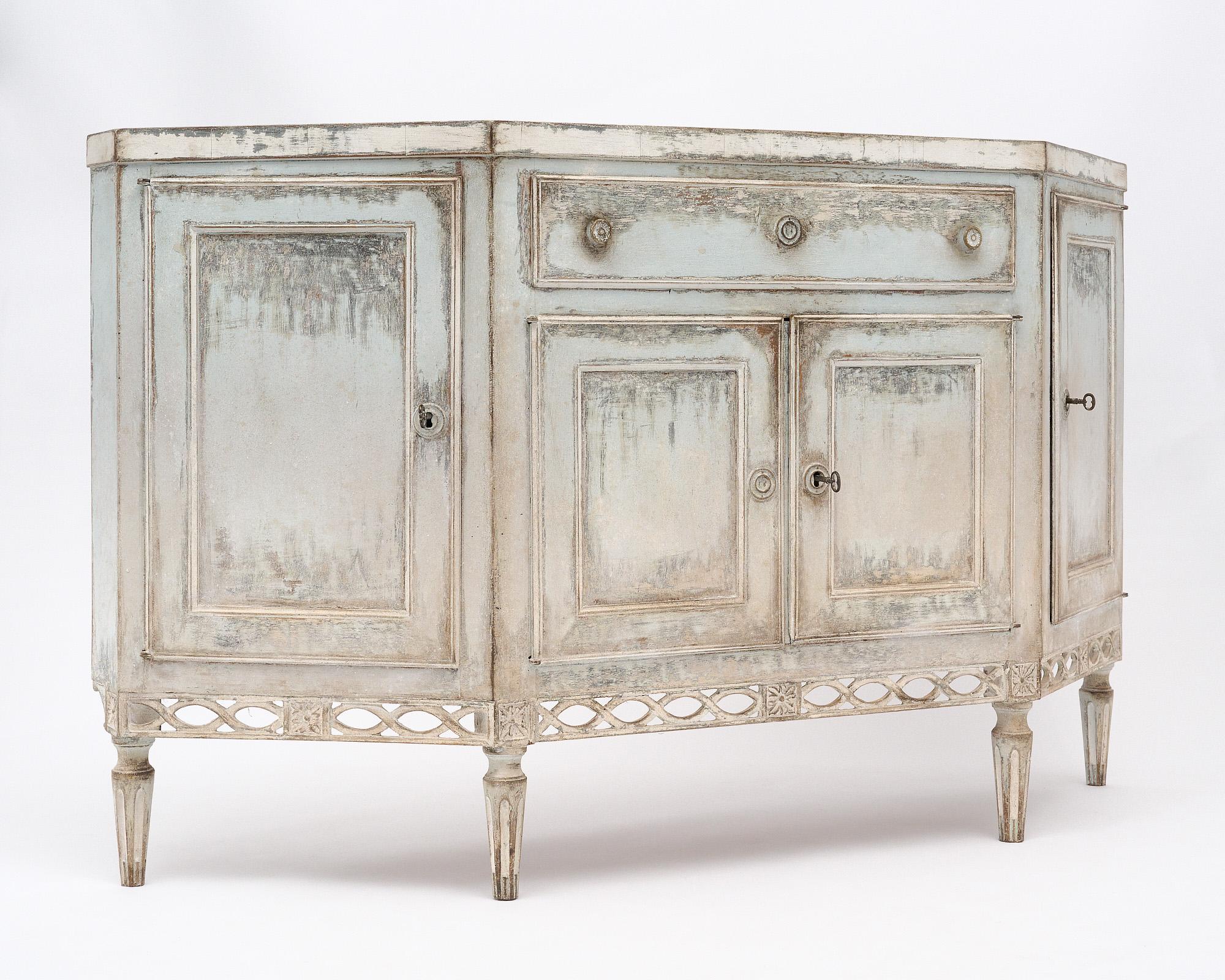 Buffet from Italy with original painted finish. This case piece has four doors that open to interior shelving and one dovetailed drawer. The locks are in working order with original keys. The case piece has a light blue finish while the top is