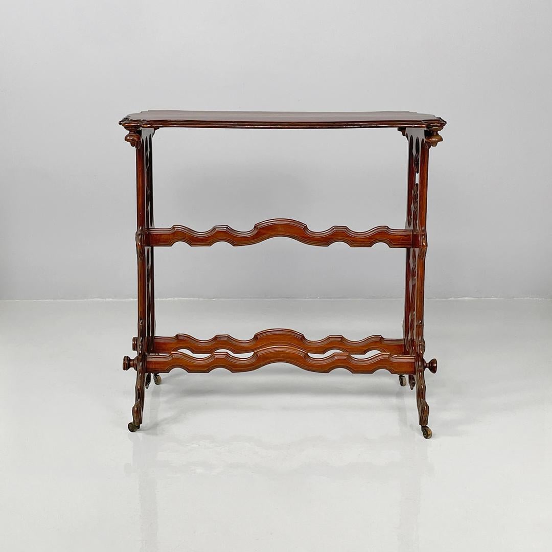 Italian antique rectangular wooden coffee table with wheels, 1800s
Rectangular coffee table made entirely of finely crafted wood. The top features a central oval decoration. The legs, with decorated profiles, follow rounded and curved lines; the