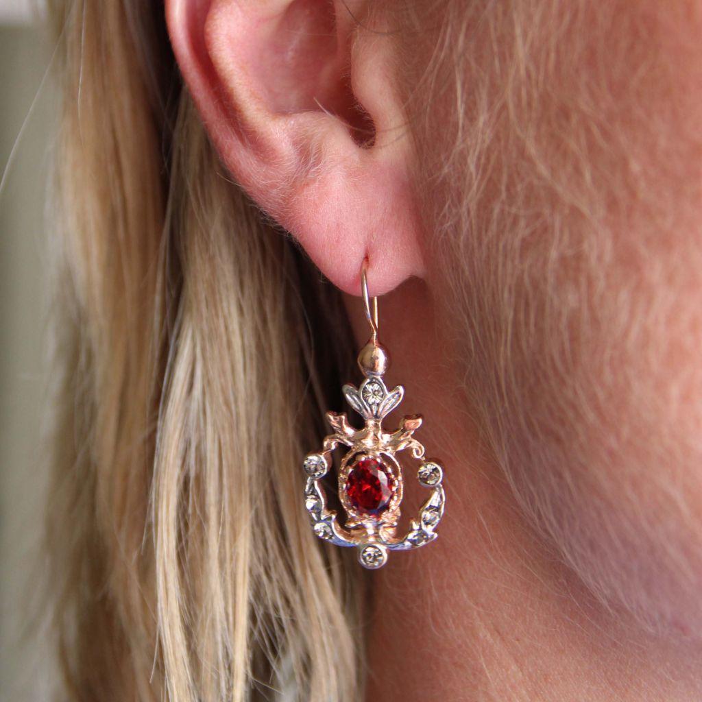 Earrings in vermeil, silver and rose gold.
Lever- back earring, each is set with a red crystal and small crystals on a chiseled and openwork decor. The clasp is a swan neck with safety hook.
Total length: 4 cm, width at widest: 1.9 cm, thickness at