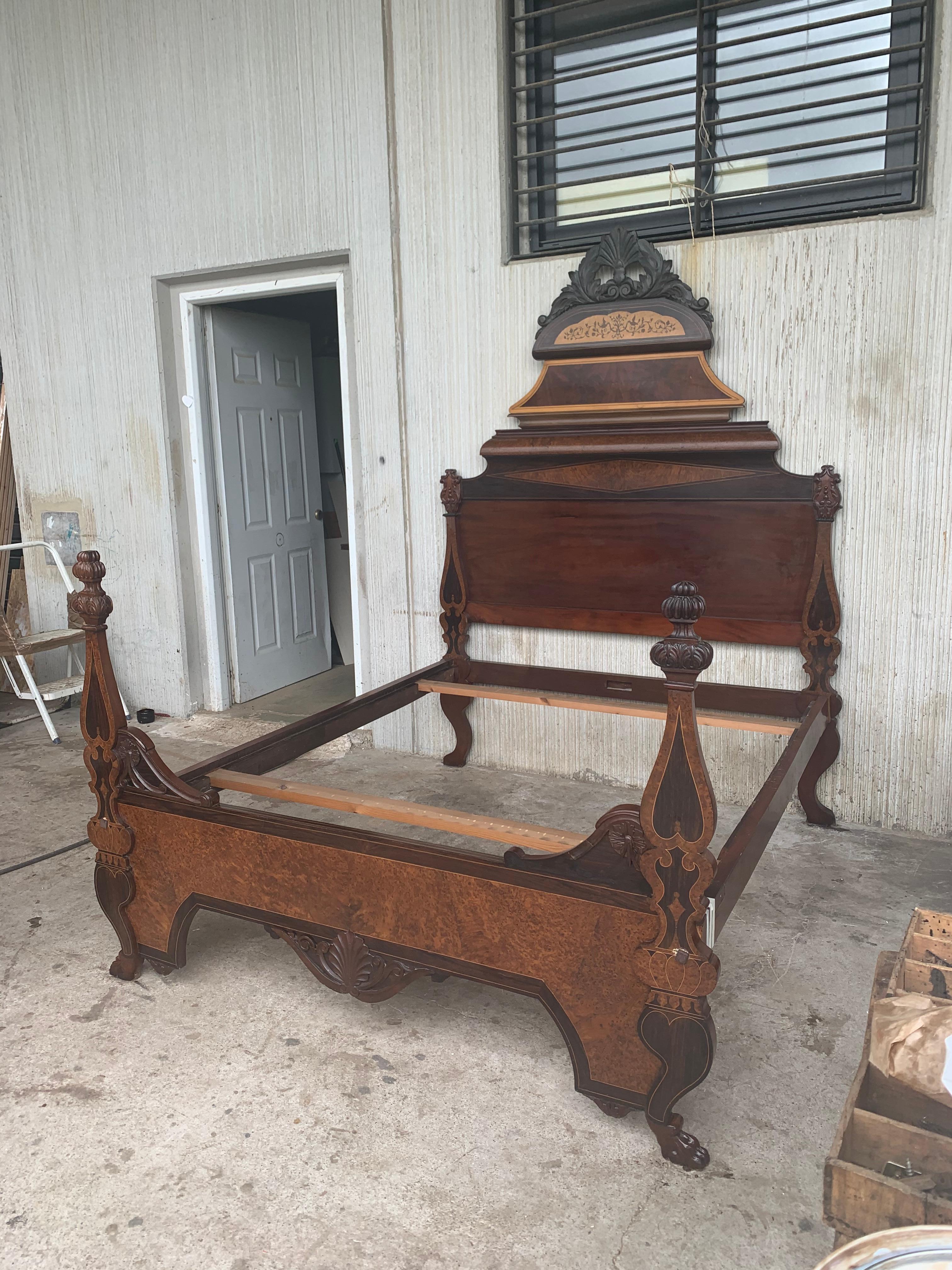 Mid-19th century Victorian Eastlake walnut carved Lincoln style bed. Features a high back with burled panels, carved finials, and open pediment with central shield / crest medallion (mirrored on front posts as well).