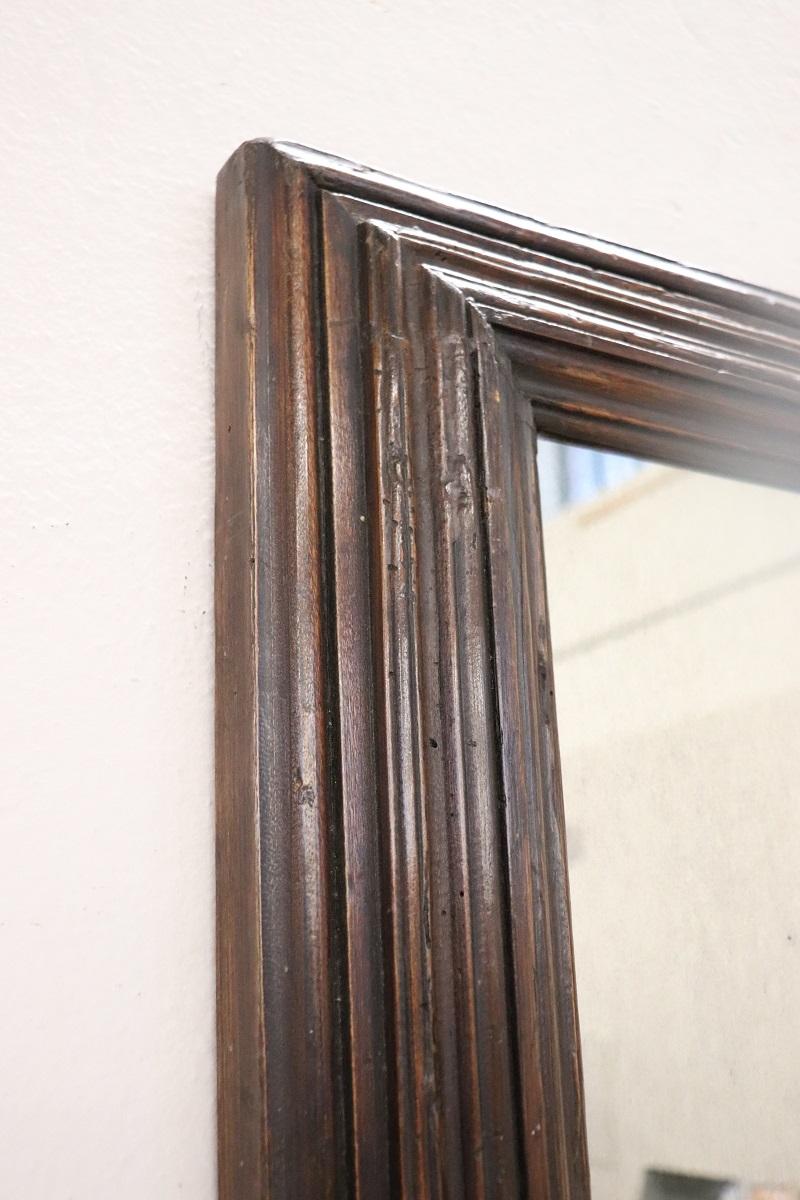 19th century Italian wall mirror with poplar wood frame, circa 1880s. An important wooden frame that presents the characteristics of time gone by. The mirror is not antique but similar to antique and has old age characteristics like an antique