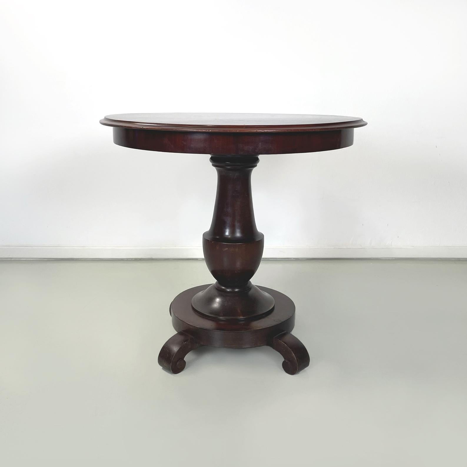 Italian antique walnut round and finely worked wood dining table, 1800s    
Antique dining table with round top, entirely in dark walnut wood. The central structure and the curly legs are turned and finely worked.
1800s of Italian manufacture.
Good