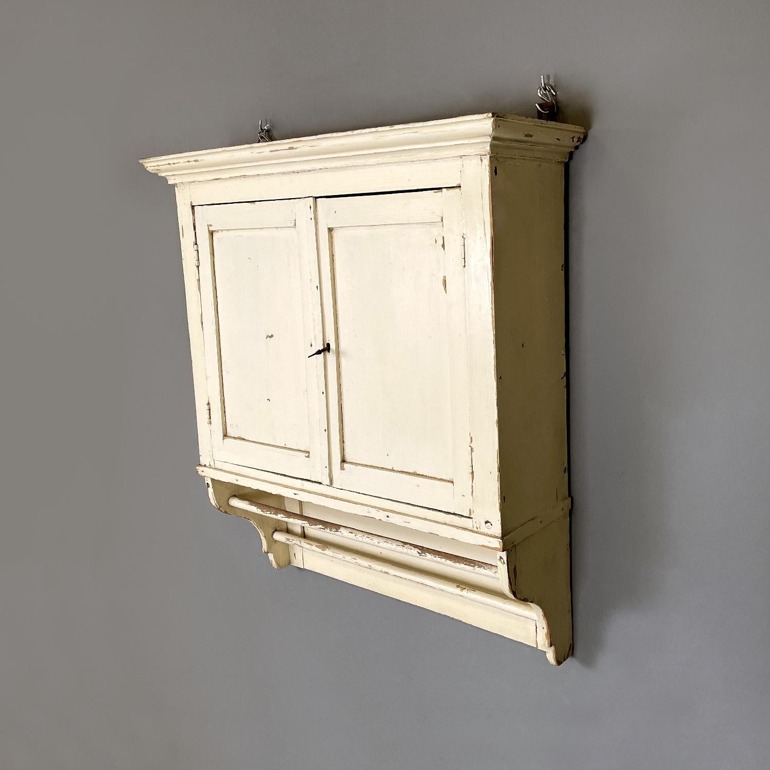 Italian antique white wooden kitchen wall cupboard, early 1900s
Wall cupboard or kitchen cabinet in white painted wood. It has two main doors with a key, inside them the space is divided into four parts by a shelf and a central divider, the left