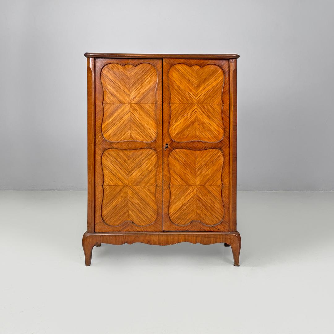Armario antiguo italiano de madera con puertas decoradas y llave, finales del siglo XIX
Tablero alto totalmente de madera. La parte superior es rectangular, en las dos puertas delanteras hay decoraciones talladas redondeadas. Dentro del armario hay