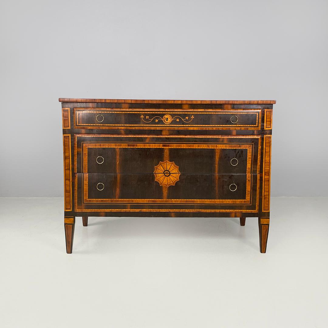Cassettone italiano antico in legno con decorazioni a intarsio, inizio '800
Cassettiera con base rettangolare. La struttura è interamente in legno ed è finemente decorata con intarsi floreali e geometrici che si ripetono sui cassetti e sui bordi. Ha
