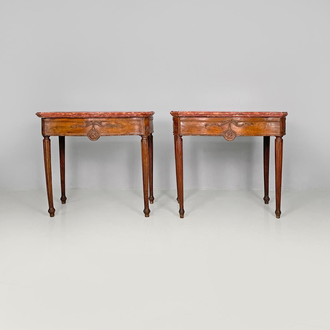 Italian antique wooden consoles with red marble tops and decorations, 1600s
Pair of consoles with top in red Verona marble. The top has shaped profiles, with the corners cut diagonally. Under the top there are decorative carvings representing a