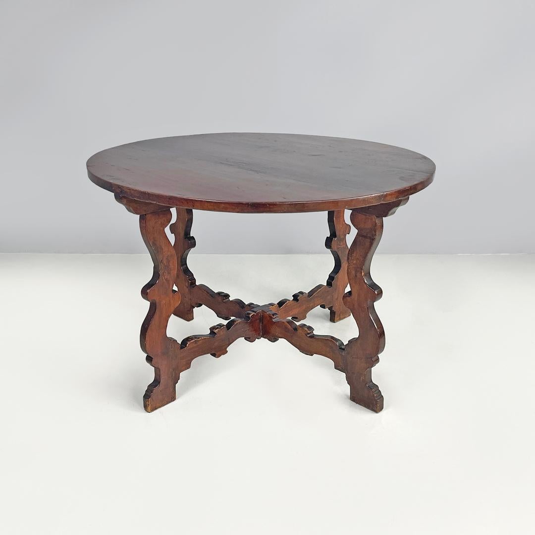 Italian antique wooden round dining table with decorated legs, early 1800s
Dining table with a round top entirely made of wood. It has four rectangular sections legs with decorated profiles that follow rounded and curved lines, the four legs are