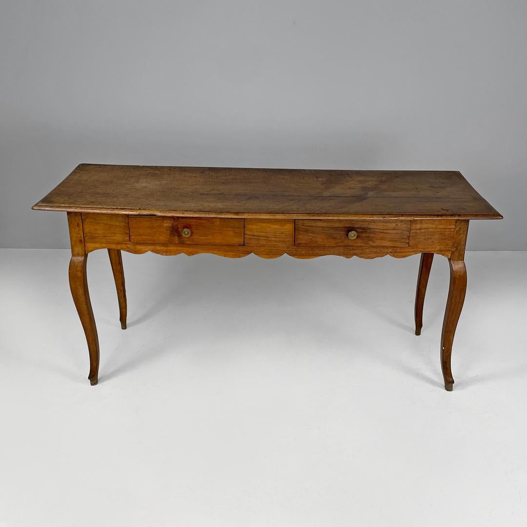 Italian antique wooden table with two drawers brass handle and wavy legs, 1700s
Dining table with rectangular top made entirely of wood. It has two drawers with round brass knobs, the edge below is inlaid. With four wavy legs and round section feet.