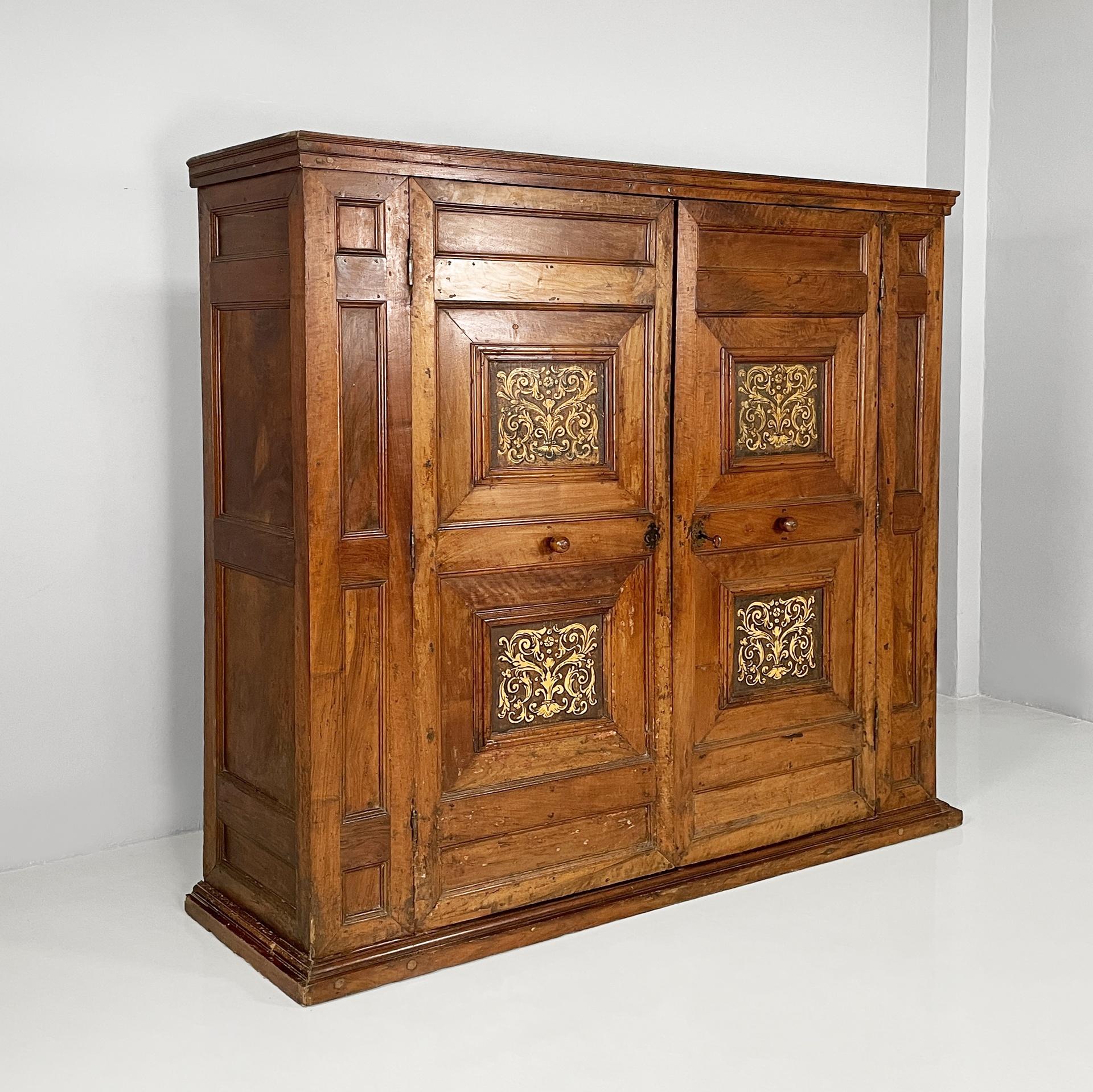 Italian antique wooden wardrobe with decorated doors, 1800s
Double-door wardrobe with rectangular base in wood. The doors have squares with painted decorations. The handles are spherical. The key is present and works. The wooden interiors covered in