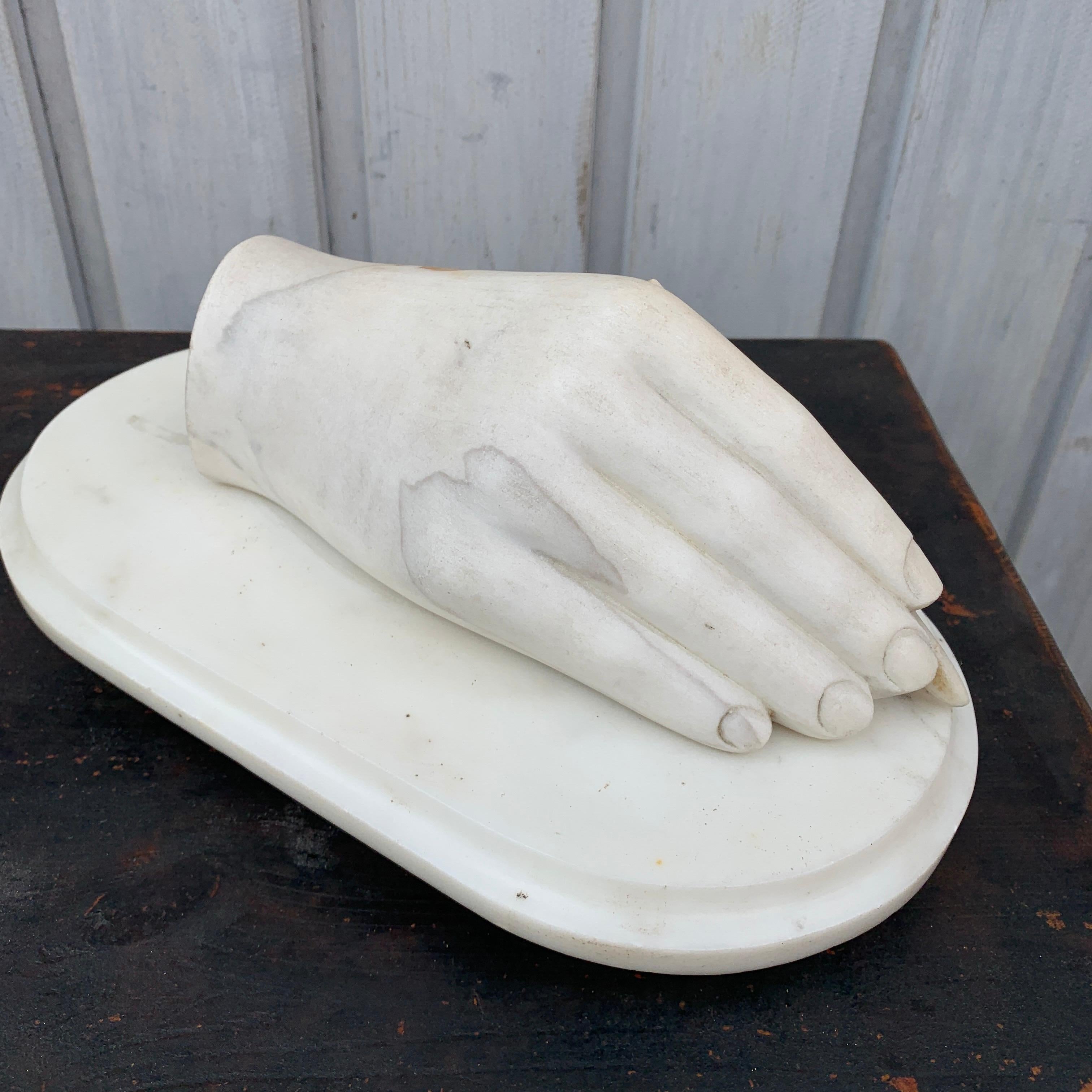 Early 19th Century white marble artist hand sculpture.
Delicate and smooth, this lovely white marble sculpture of a hand delicately holding a pen between it's fingers is the perfect gift for the writer or the artist in your life. The piece would be