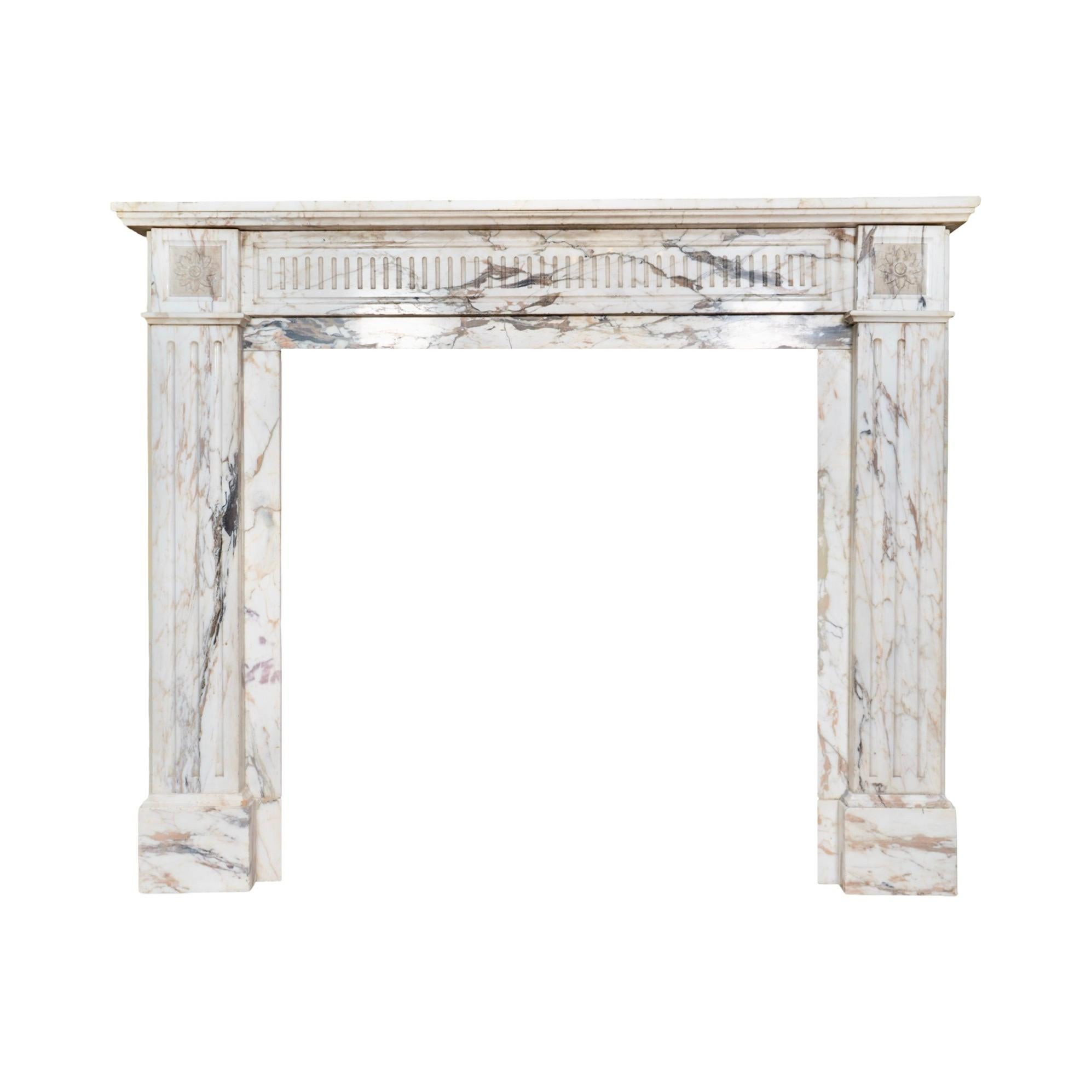 This 19th-century mantel from Italy is carved from Arabescato Corchia marble, a prized Italian stone celebrated for its dramatic veining. The marble features a creamy white base accented with bold swirls of warm grey, gold, and earthy undertones,