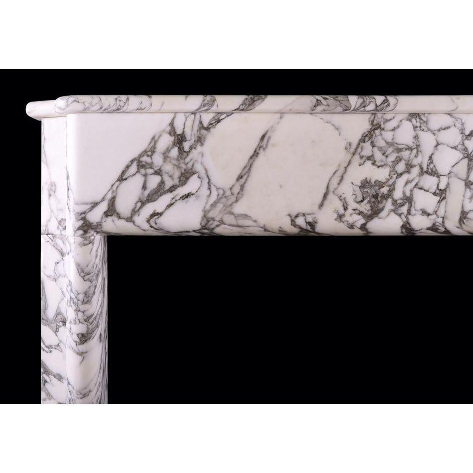 An Italian Arabescato marble fireplace in the Art Deco style. The moulded jambs surmounted by plain frieze and shaped shelf above. Modern. 

Additional information:
Shelf Width: 1363 mm / 53 ⅝