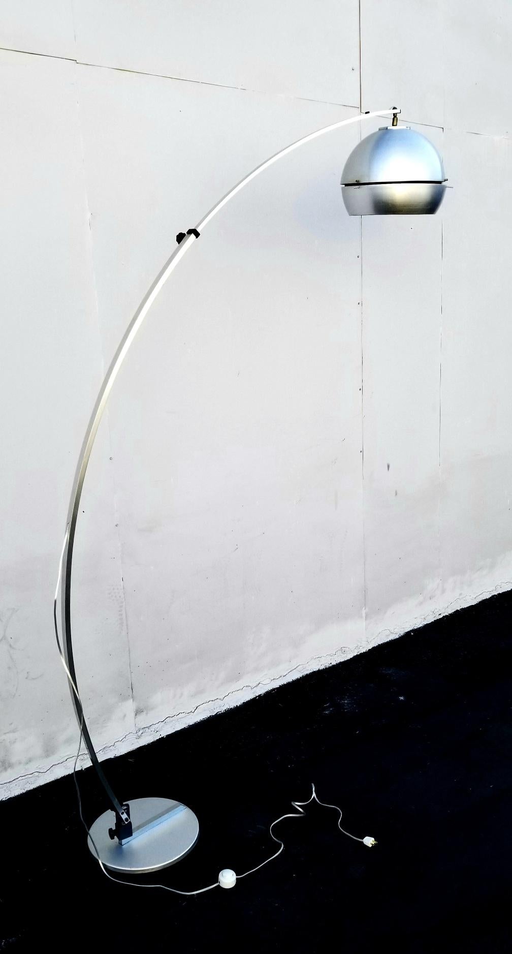Lampe à arc italienne des années 1960 composée d'une base en métal lourd, d'un arc extensible en aluminium brossé et d'un abat-jour en métal-aluminium. Le lampadaire a une portée d'arc réglable et sur la base il y a aussi deux boutons pour enlever
