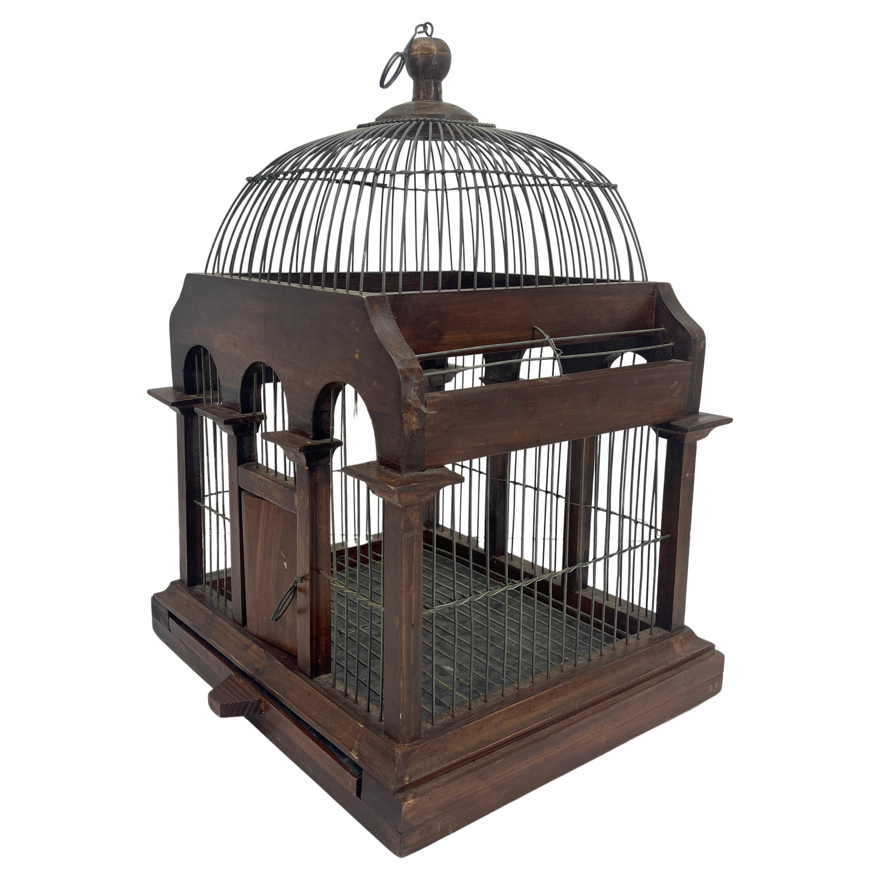 Small rectangular Italian bird cage as an architectural dome building with columns, front door and metal tray.