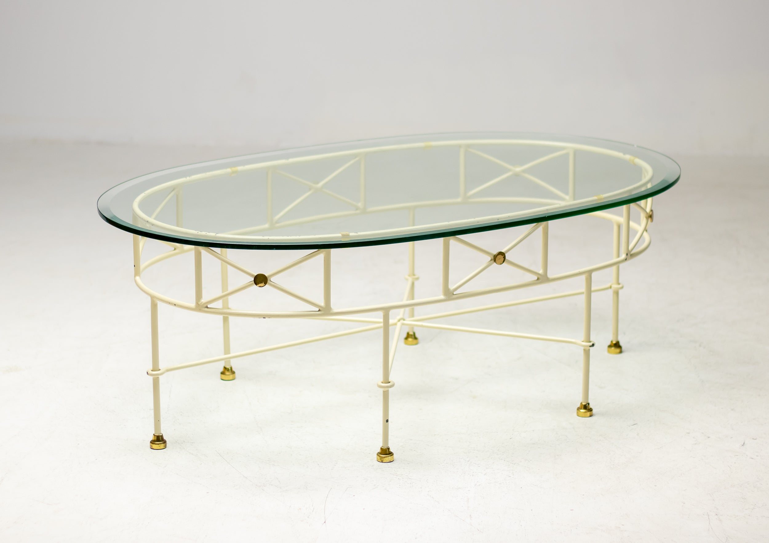 Elégante table basse ovale à plateau en verre de style italien du milieu du siècle dernier.
Base en acier émaillé blanc avec pieds en laiton et plateau en verre de cristal biseauté.
Belle présence, pièce idéale pour donner à une pièce cette touche