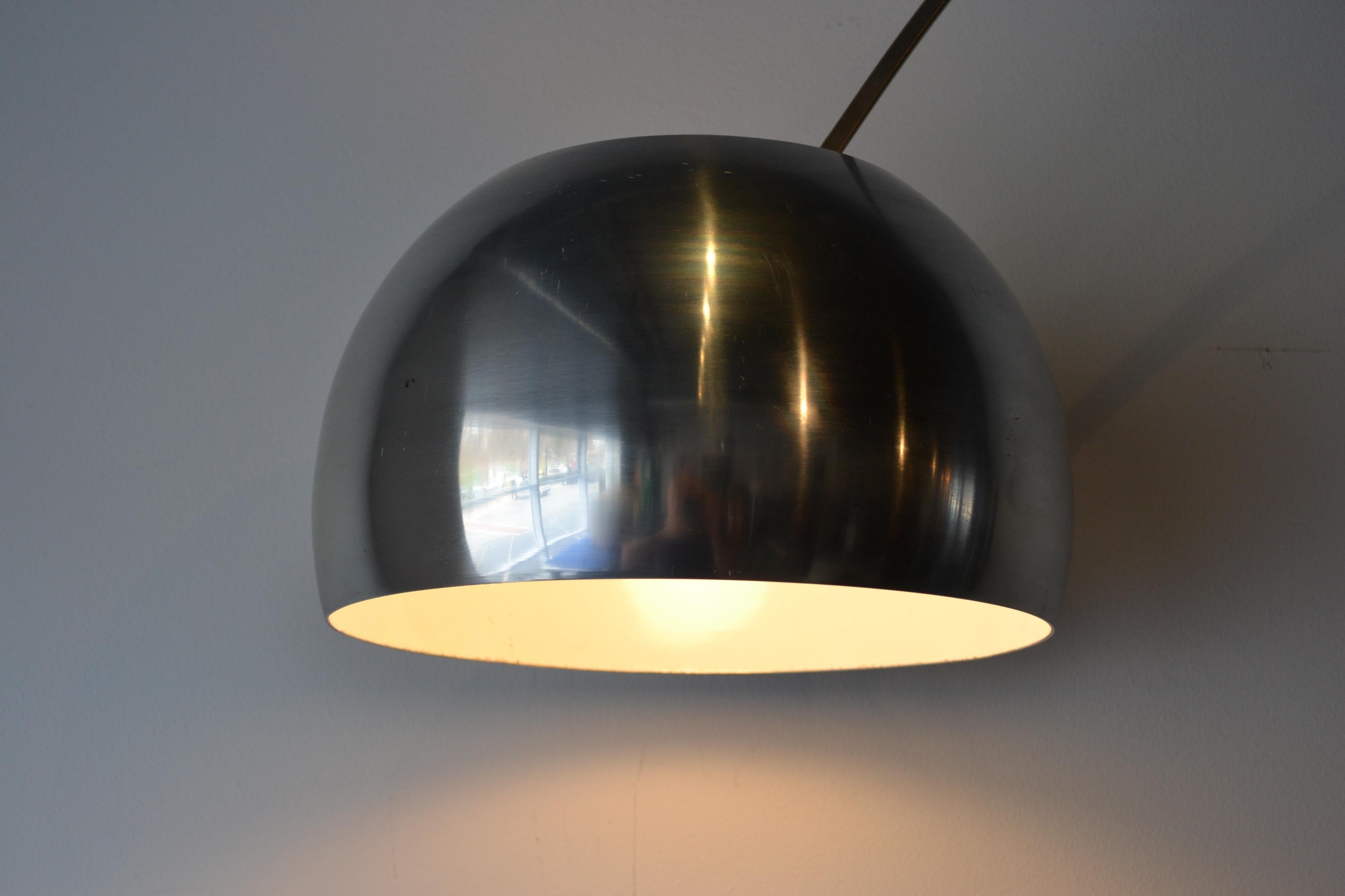 La lampe Arco est un plafonnier moderne conçu par les frères Pier Giacomo et Achille Castiglioni pour Flos, en Italie.
La lampe est caractérisée par un pendentif suspendu en aluminium filé, fixé à une plaque verticale de marbre de Carrare par un