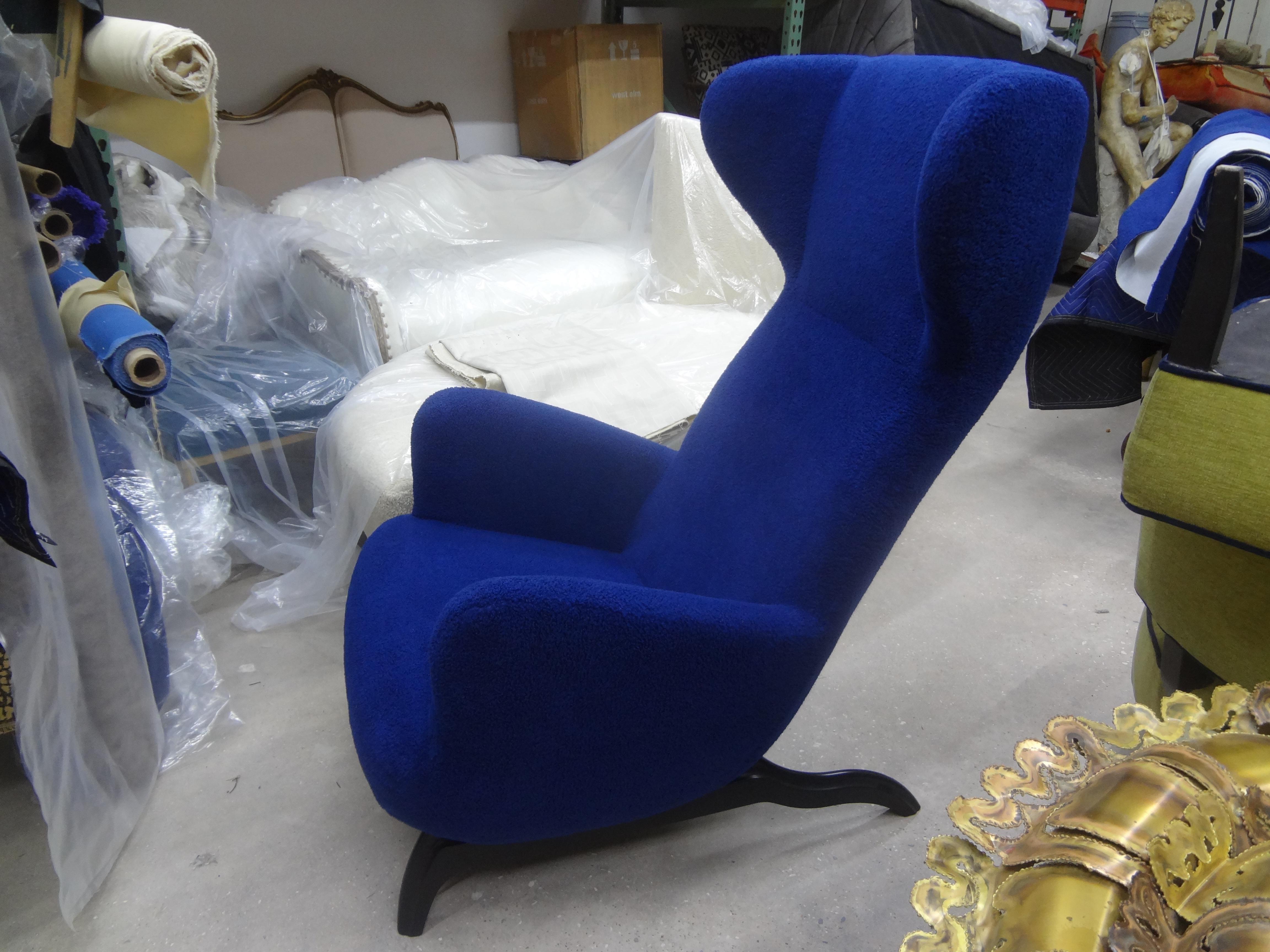 Italian Ardea lounge chair after a design by Carlo Mollino.
 
Stunning curvaceous Italian lounge chair with exaggerated ebonized legs professionally upholstered in plush blue bouclé. 
This chair was acquired out of an estate in Milan in 2012. It had