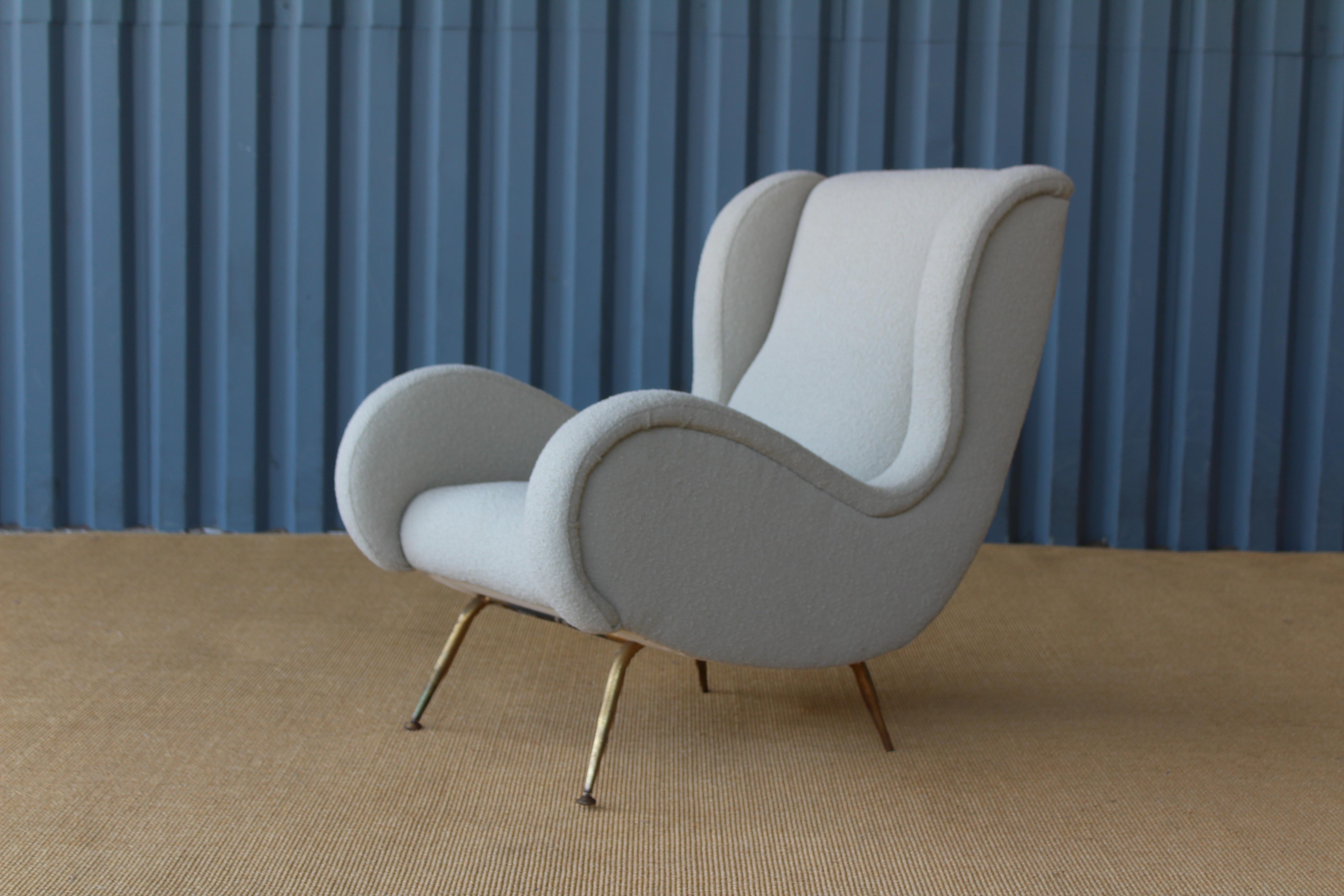 Midcentury 1950s Italian armchair with new beige bouclé upholstery by Knoll. Brass base and feet with pivoting glides shows original patina.