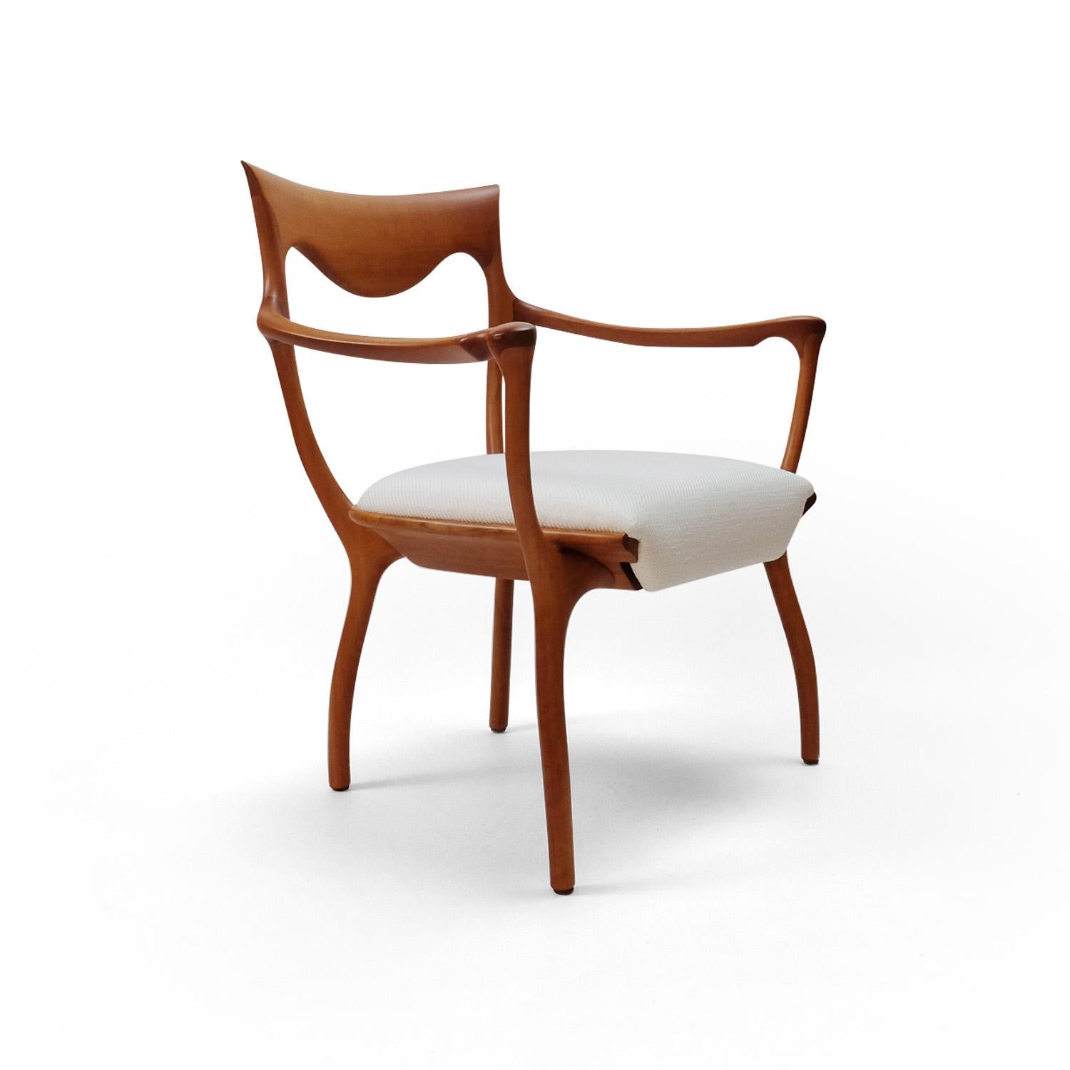 Italian-made chair (model Hypnos) constructed from 22 individual wooden parts, all handmade and with sustainably sourced walnut. 

The seat is upholstered in a white woolen fabric.