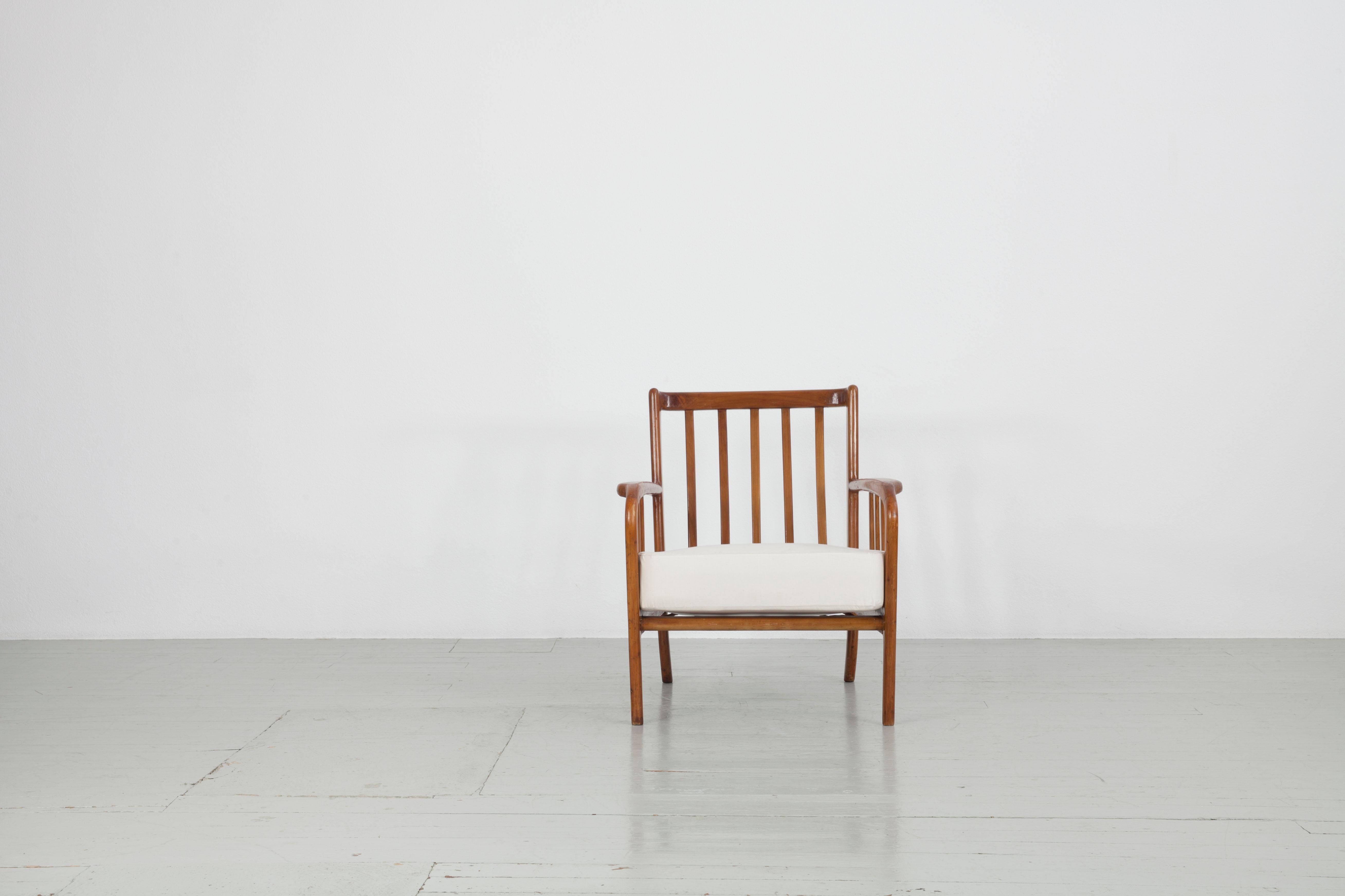 Ce fauteuil italien a été fabriqué dans les années 1940 dans le style de Paolo Buffa. Deux coussins blancs reposent sur le cadre en bois de cerisier magnifiquement travaillé et ont été remis à neuf pour votre choix de rembourrage. Le meuble est en