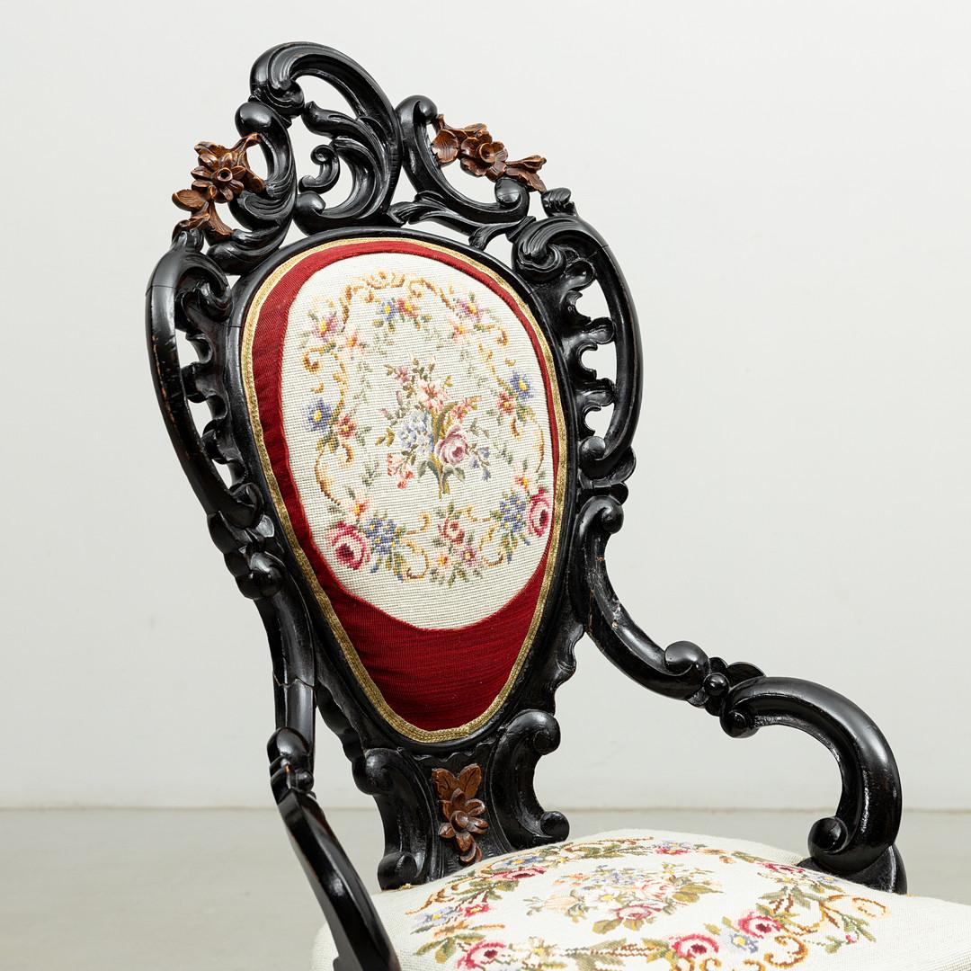 Painted black with richly cut decoration around padded and upholstered back tray hand embroidered fabric, turned legs under padded and upholstered seat. Made in Italy in about 1870