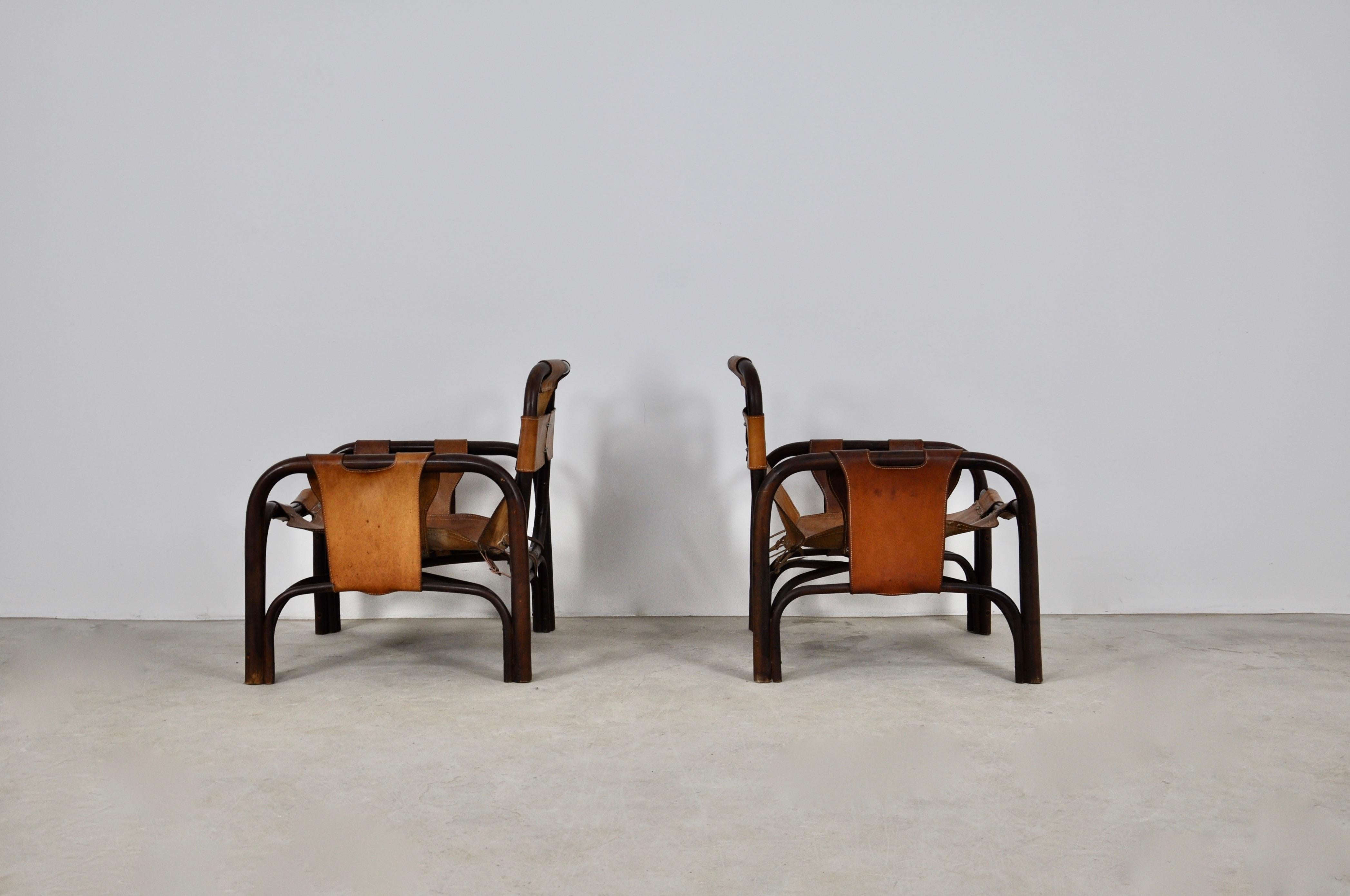 Pair of leather and bamboo armchairs. Wear due to time and age of the chairs. Measure: Seat height: 37cm.