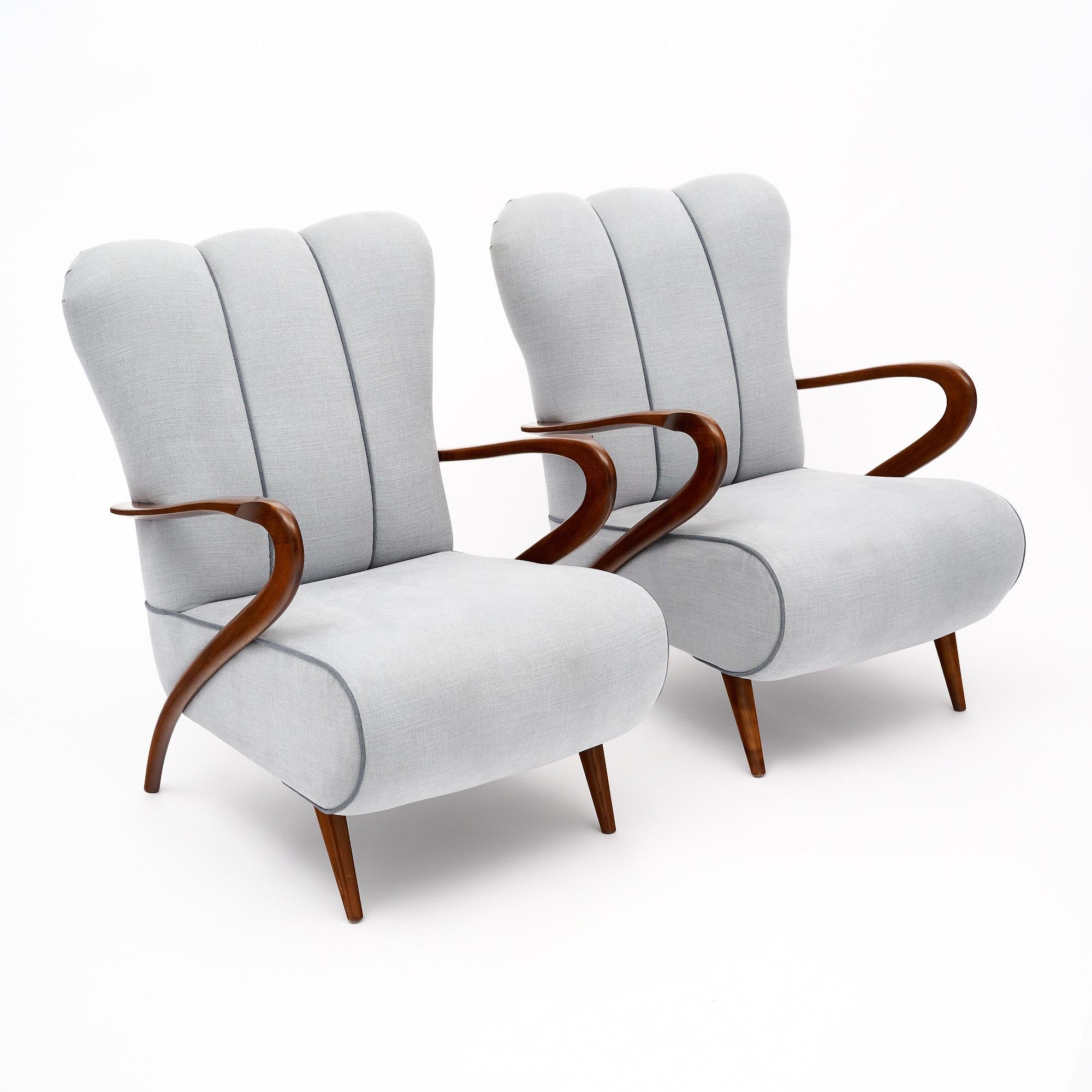 Armchairs from mid-century Italy attributed to Guiglielmo Ulrich, noted Italian architect and designer. These chairs are made with solid wood construction and iconic curved arms. The original gray-blue upholstery is in good condition and features a