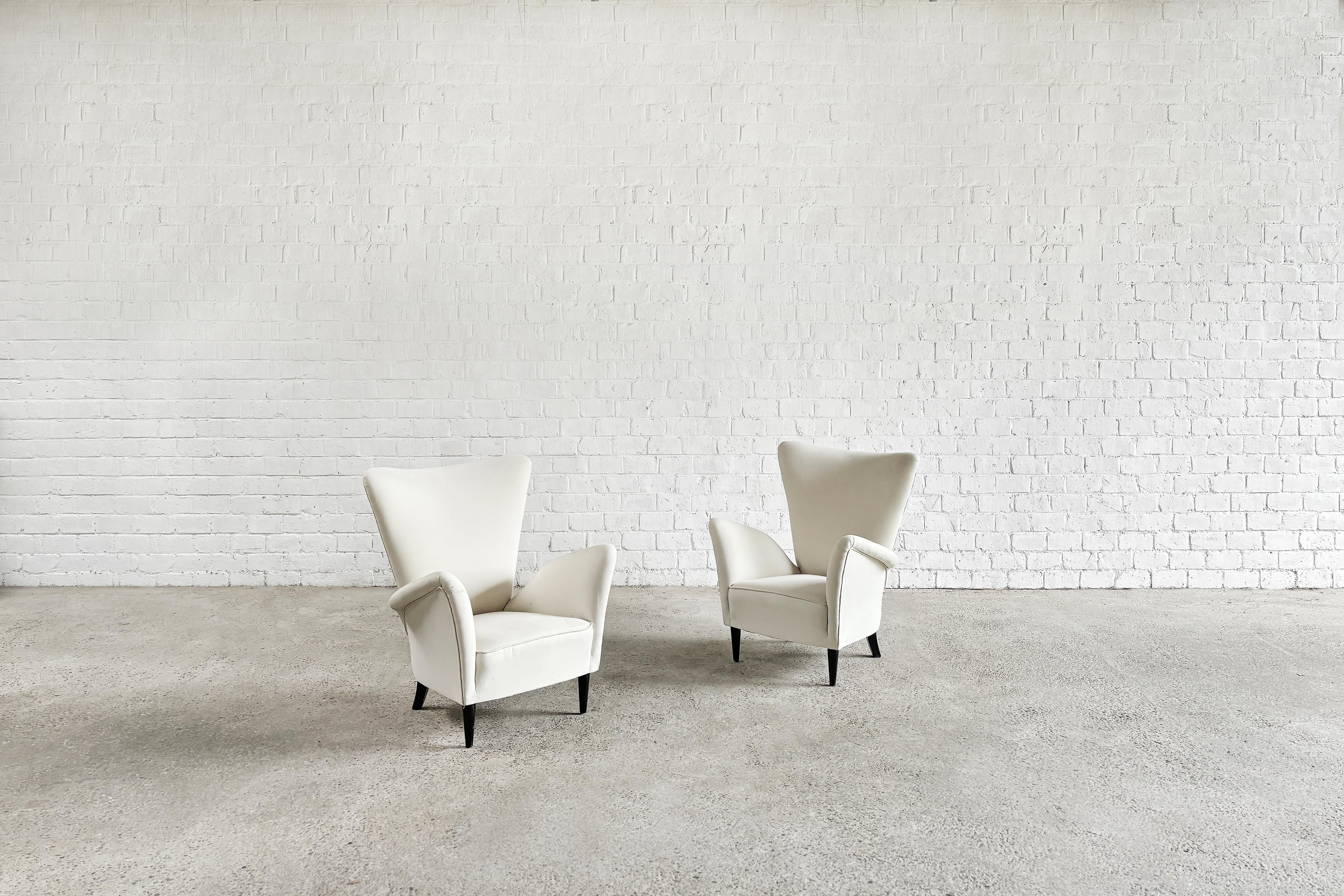 Paire de chaises longues italiennes aux formes sculpturales conçues par Gio Ponti pour l'hôtel Bristol Merano en Italie à la fin des années 1940 ou au début des années 1950. Revêtement en coton blanc et pieds en bois laqué noir.

État d'origine