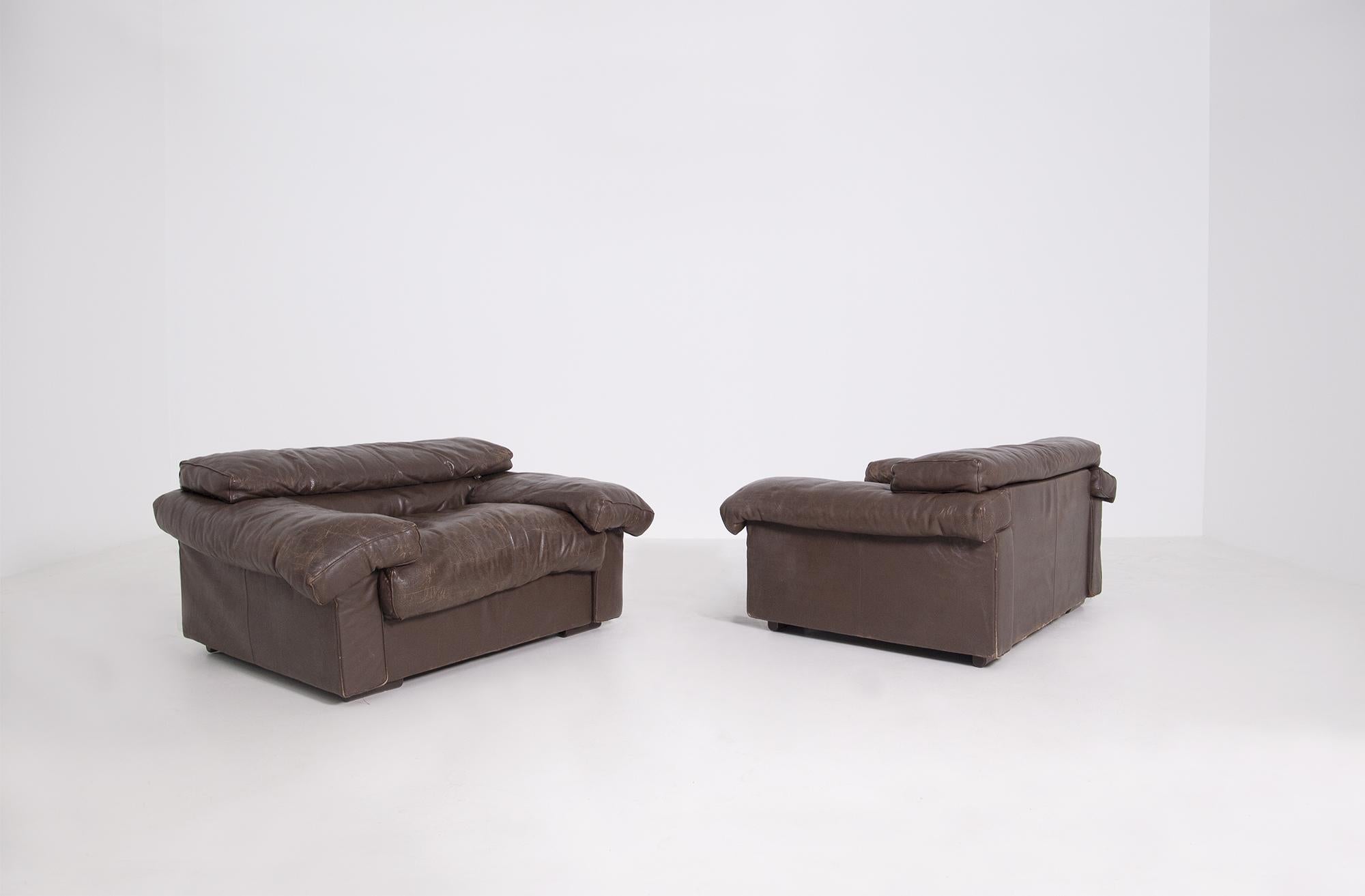 Elegant and modern pair of large armchairs designed by Tobia Scarpa for the B&B Italia manufacture in 1973. The pair of armchairs is upholstered in a beautiful brown leather. The armchairs are the Erasmo model with the original label of the