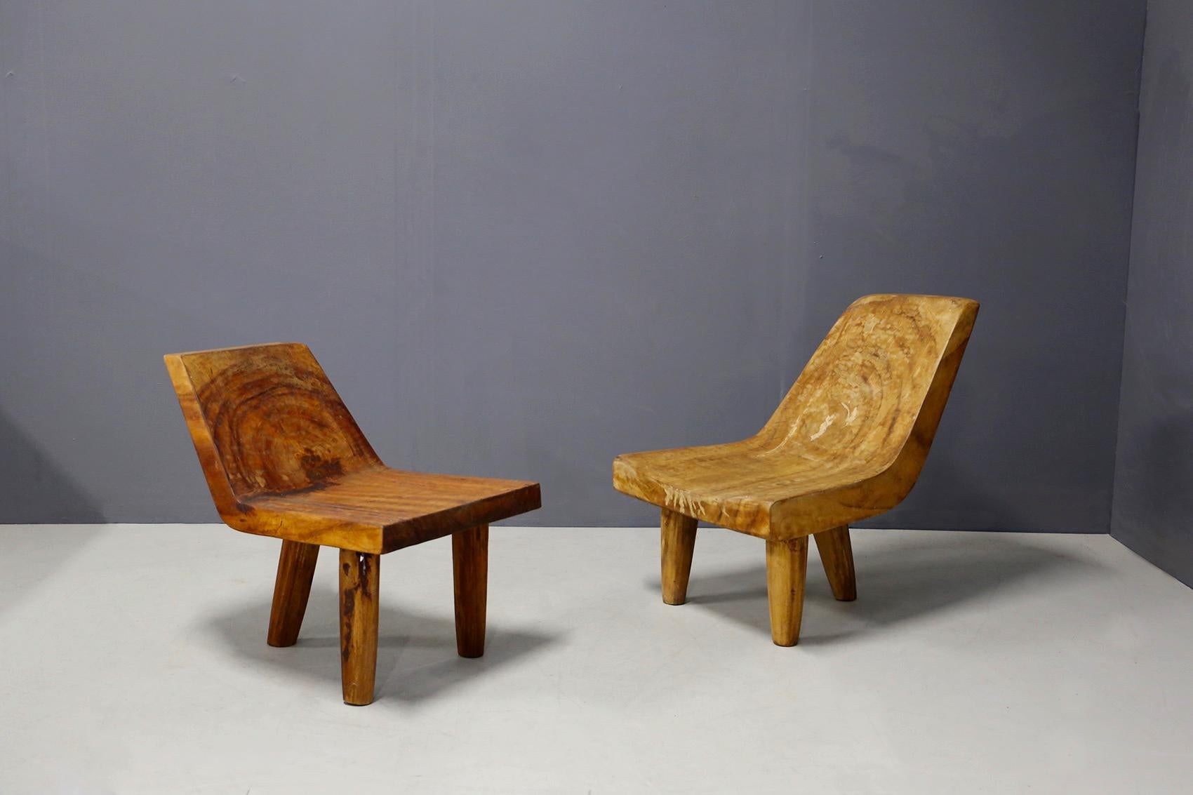 Eccentric armchairs sculpted by a contemporary Italian master from 2000. The armchairs are made of solid wood. The particularity of the chairs are made of a single block. The two armchairs are different, one smaller than the other. The armchairs are