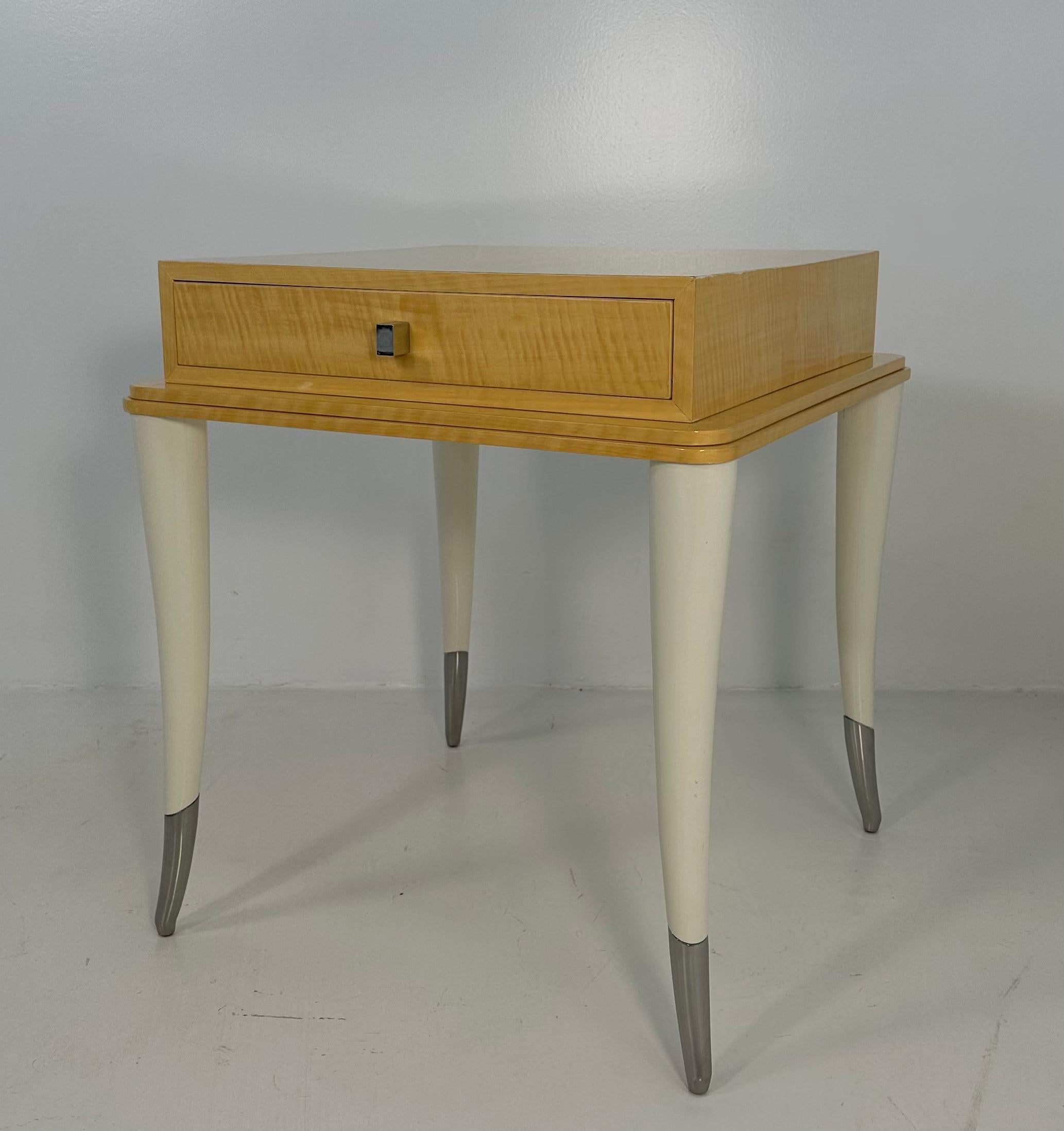 This elegant yet particular and rare side table was produced in Italy in the 1980s. 
The top is in maple wood and lays on four cream lacquered legs. 
The interiors are in cream colored velvet, while the tips of the legs and the handles are in