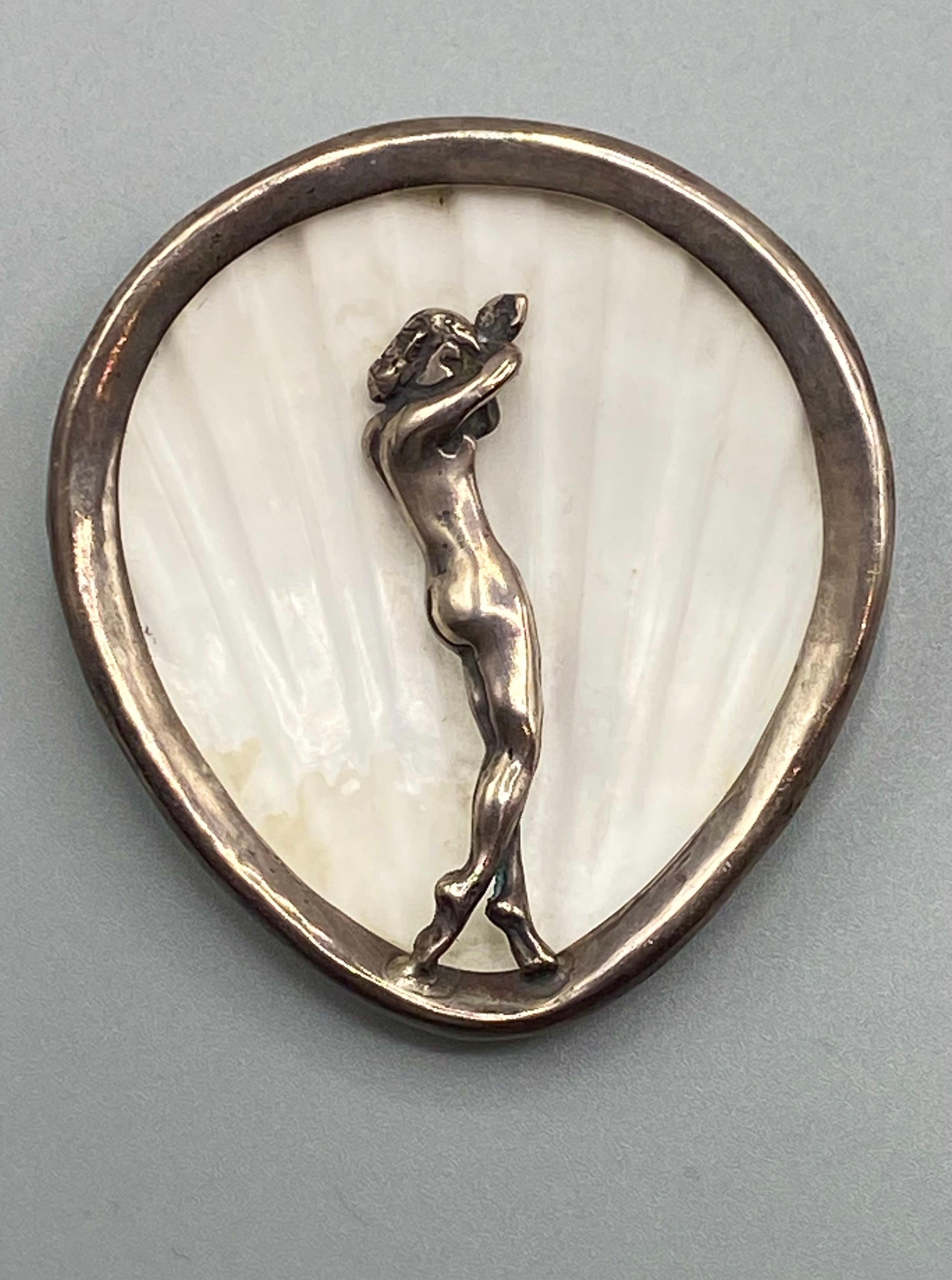 A stunning and Art Deco brooch of the Birth of the goddess Venus. It is mostly likely Italian and was purchased there. The brooch has a natural scallop shell body mounted in a matching shape hand made sterling silver frame. The concave side of the