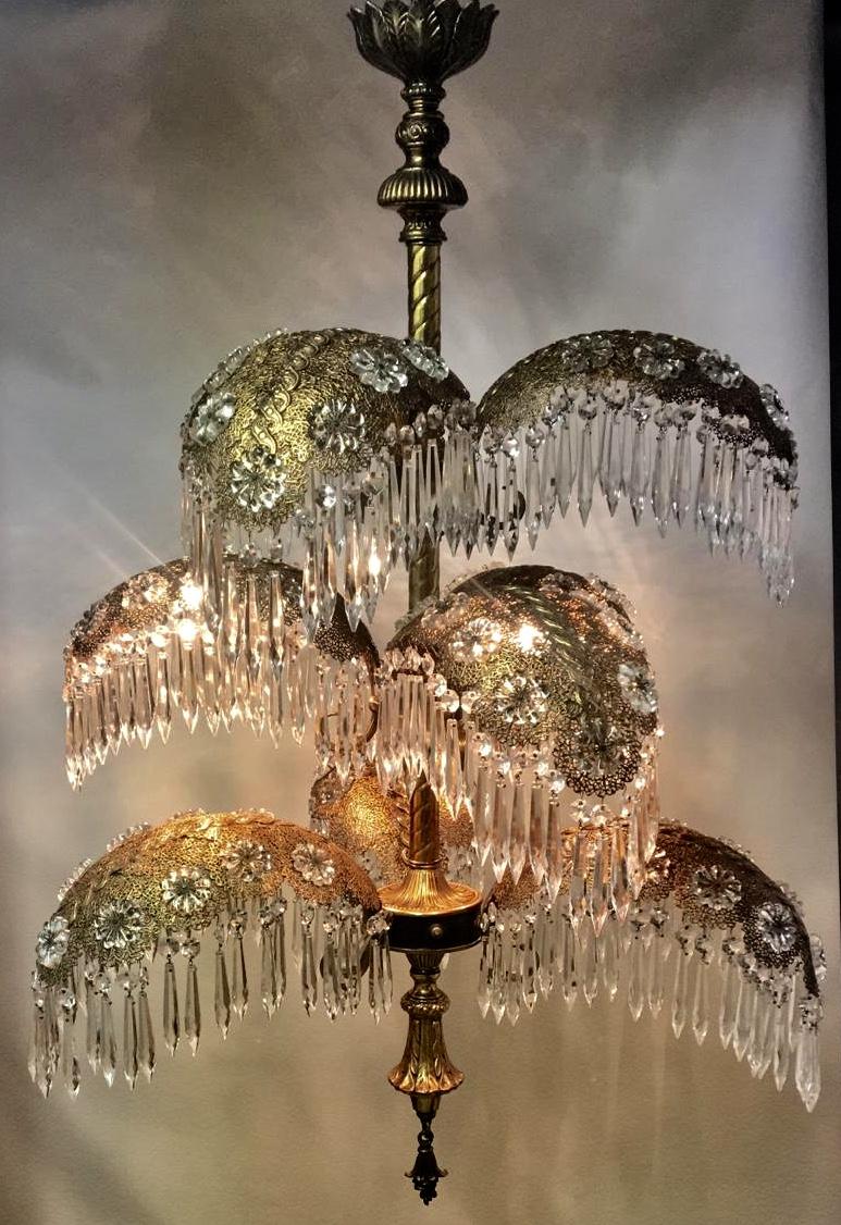 A beautiful, grand Art Deco palm tree chandelier, circa 1940s.
9 fronds dripping with hundreds of crystal prisms, Aurora Borealis Rosettes, Brass Filligree Detailing. 9 Light.

Rewired for US.